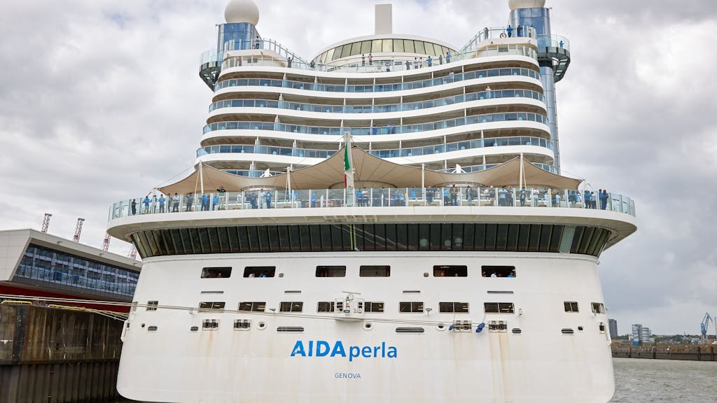 Besatzungsmitglieder des Kreuzfahrtschiffes AIDA perla freuen sich über ein Konzert, dass auf einem ihnen gegenüber liegenden Fahrgastschiff im Hamburger Hafen für sie gespielt wird.