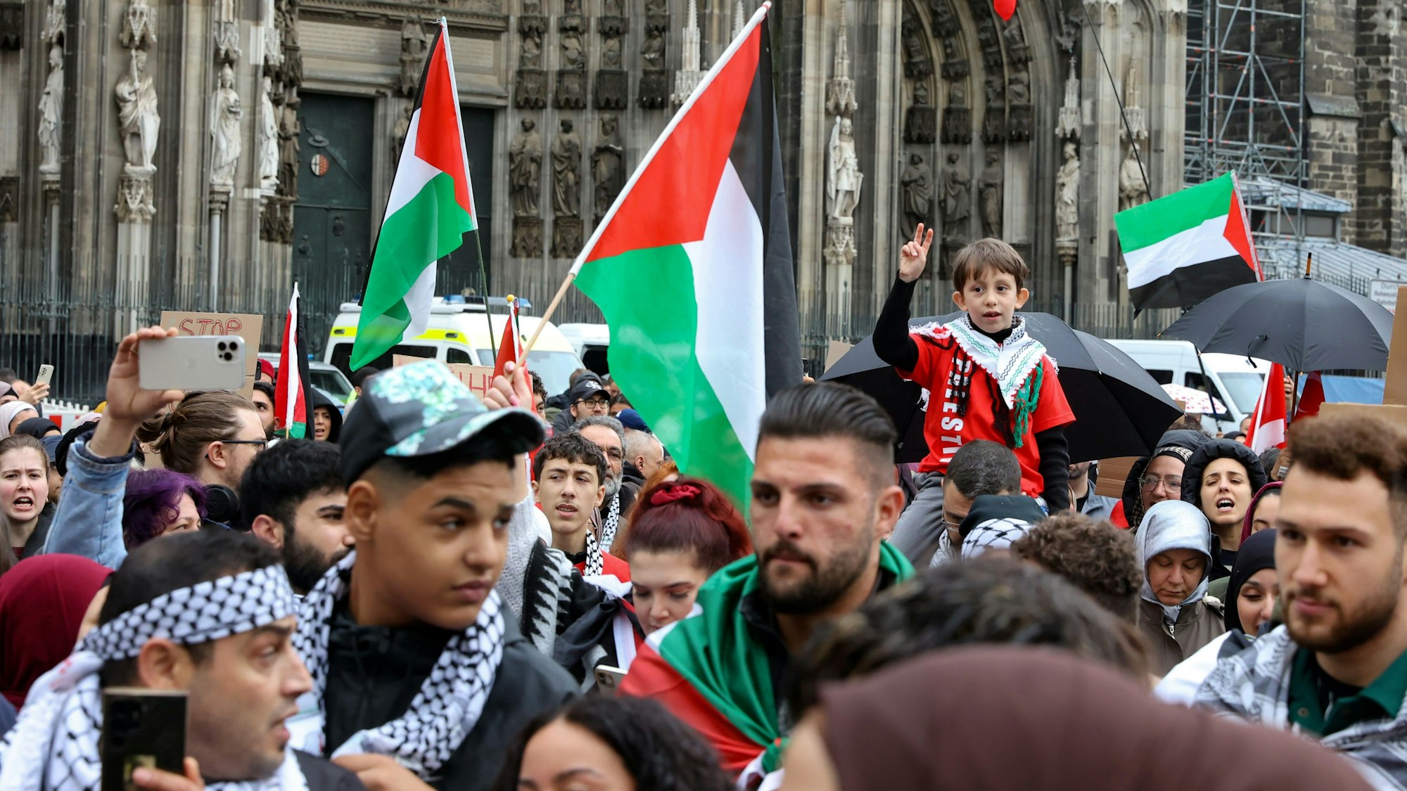 Menschen mit der palästinensischen Flagge vor dem Dom.