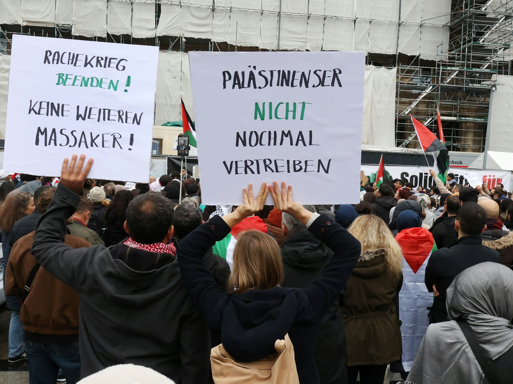Demonstrierende halten Plakate hoch, unter anderem mit der Aufschrift „Palästinenser nicht nochmal vertreiben“.


