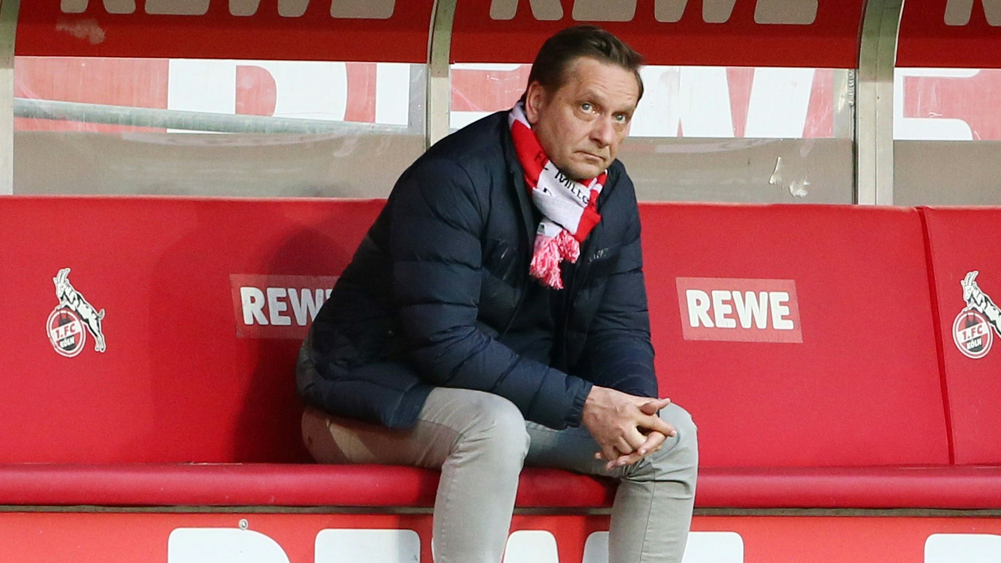 Horst Heldt sitzt beim 1. FC Köln nach einem Spiel auf der Ersatzbank.