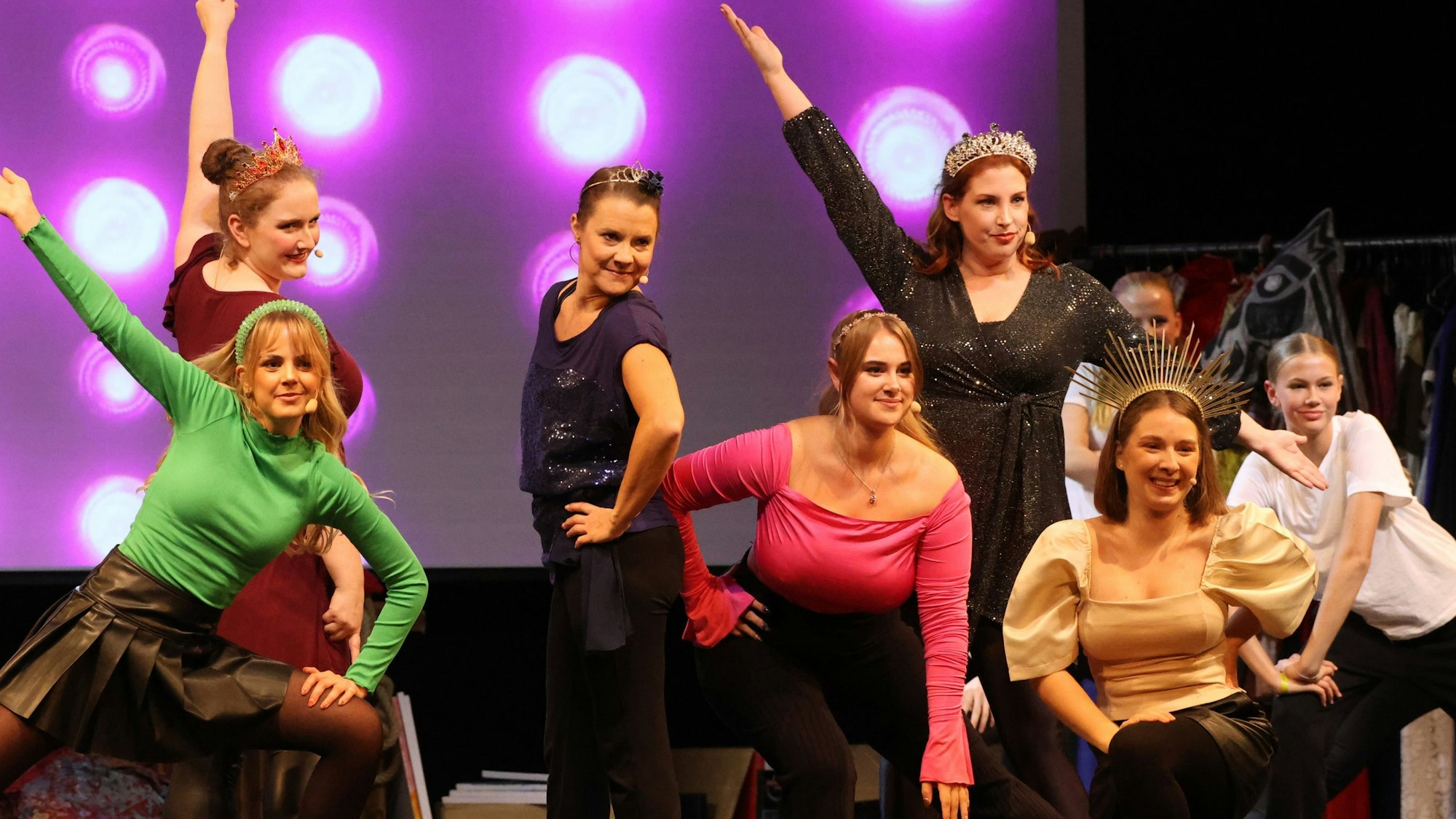 Junge Tänzerinnen posieren auf der Bühne in Formation.