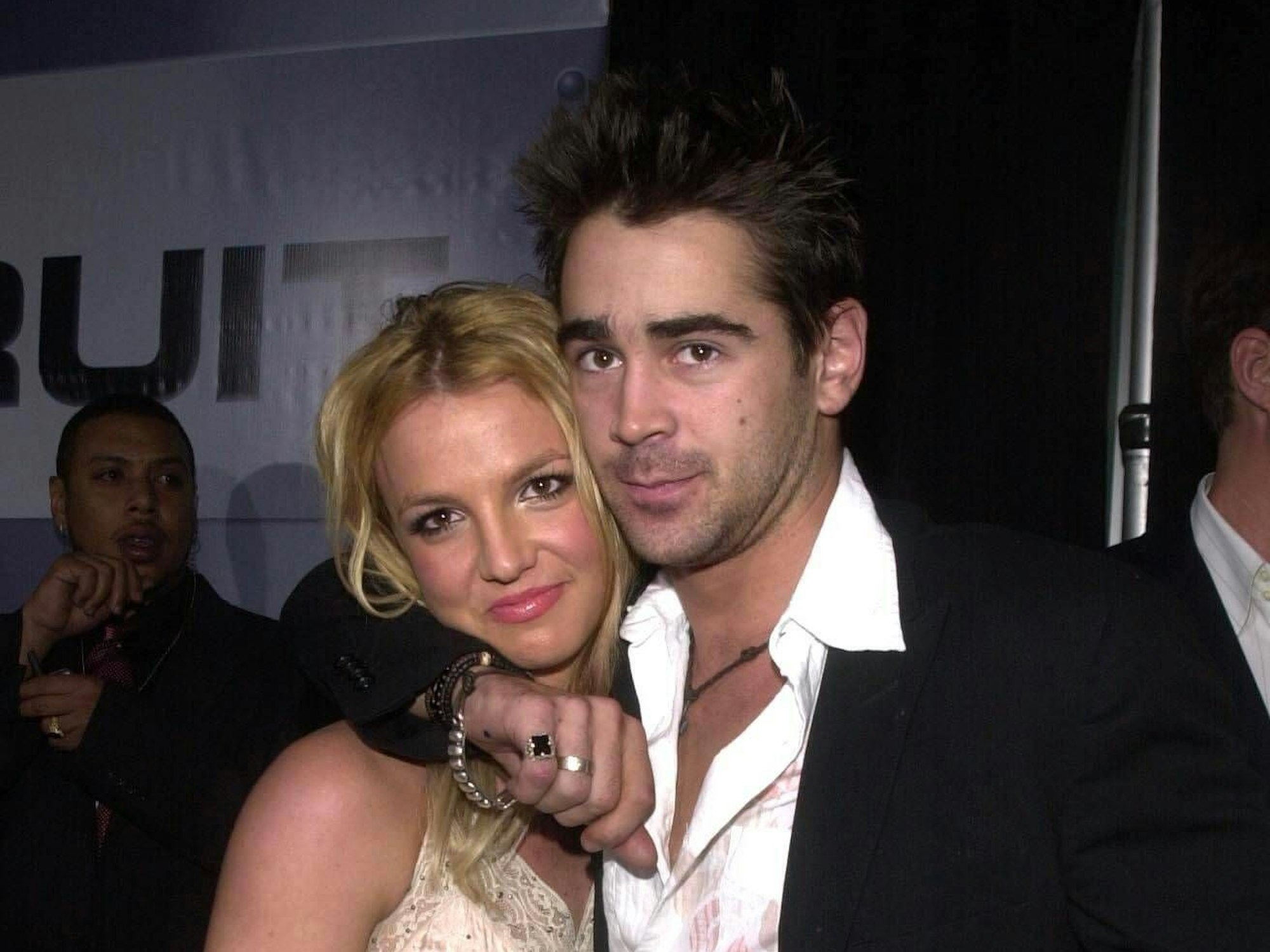 Das Foto zeigt Popstar Britney Spearsund Schauspieler Colin Farrell bei der Premiere des Actionfilms „Der Einsatz“ in einem Kino in Hollywood. Er hat den Arm um sie gelegt und beide lächeln in die Kamera.