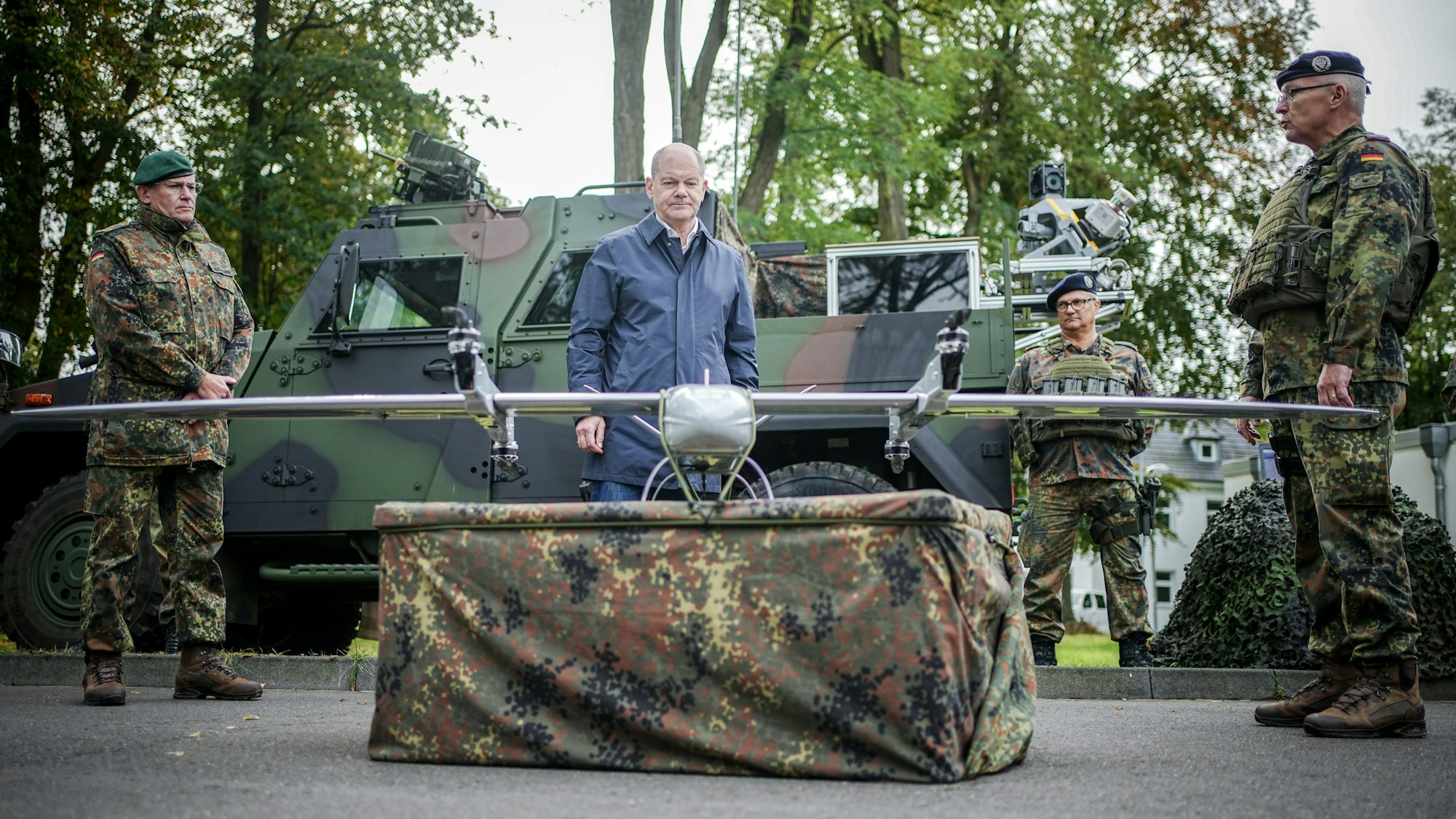 Bundeskanzler Olaf Scholz (SPD) schaut sich beim Besuch der Fähigkeitsdemonstration der Territorialen Verfügungsgruppe auf dem Militärflughafen Köln-Wahn eine Drohne an.