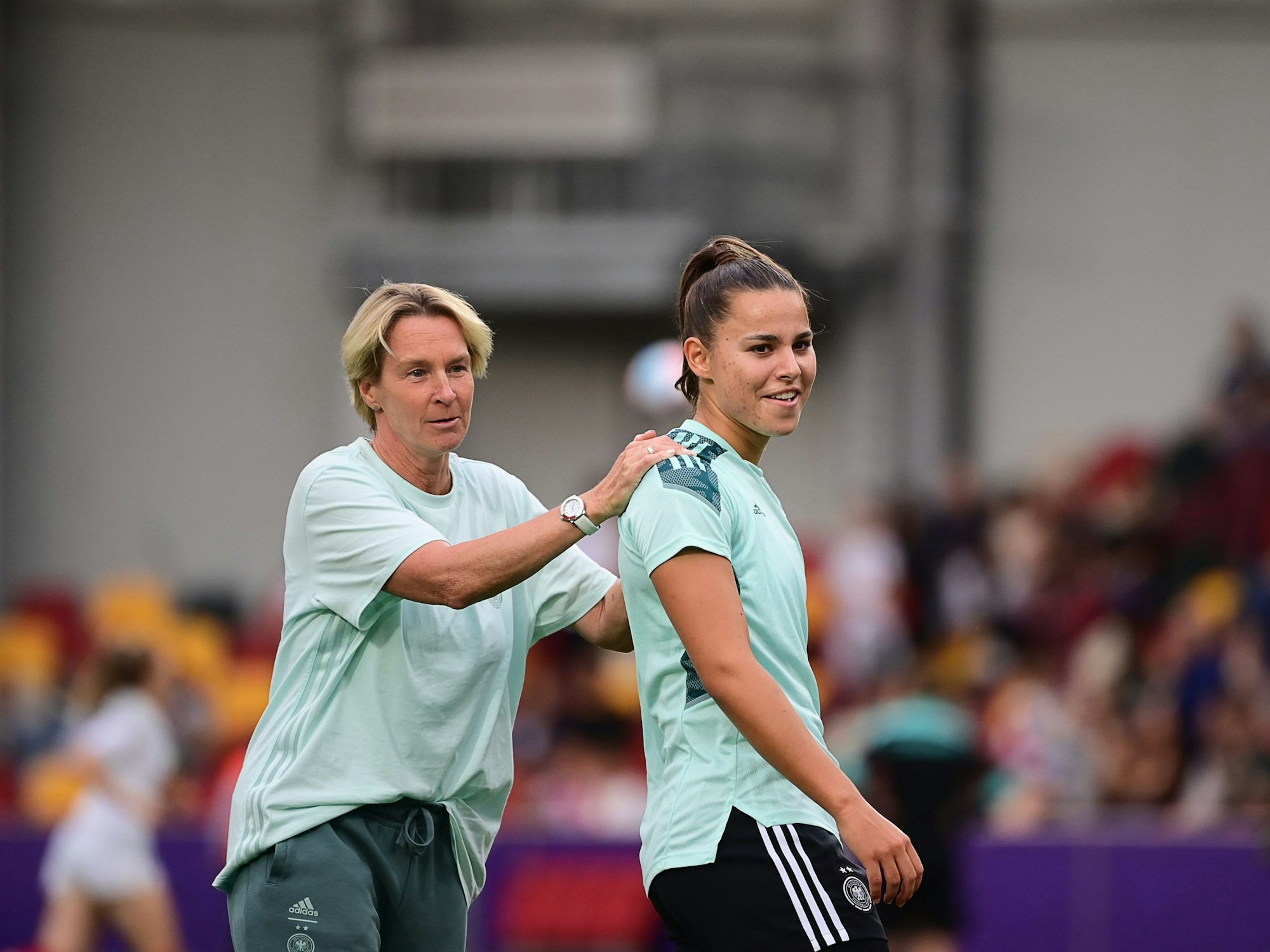 Martina Voss-Tecklenburg und Lena Oberdorf scherzen vor einem Spiel.