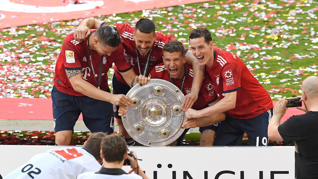 Die Bayern-Profis Niklas Süle, Sandro Wagner, Thomas Müller und Sebastian Rudy (v.l.n.r.) posieren mit der Meisterschale für Fotografen.