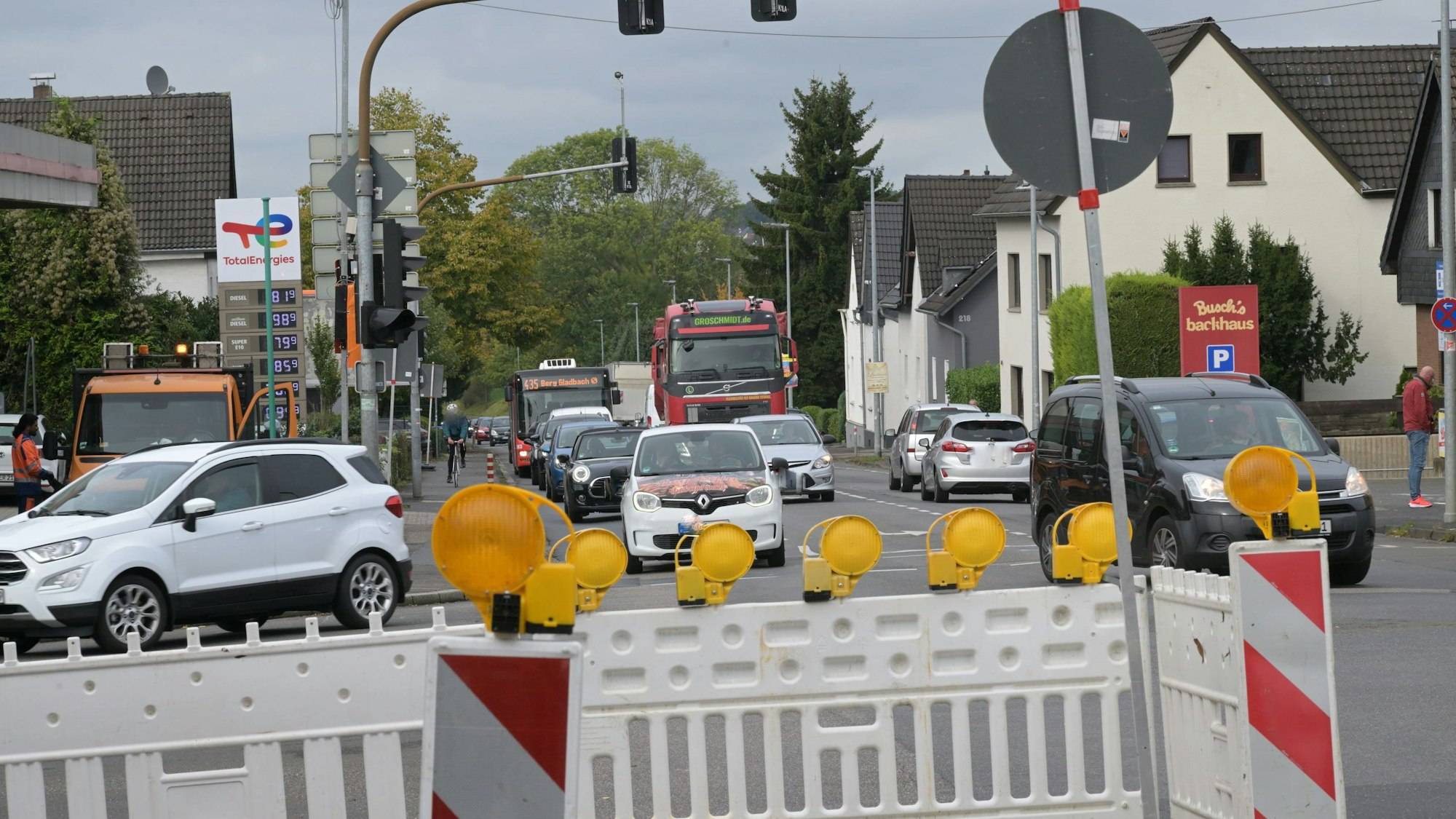 Autos biegen an einer Kreuzung links und rechts ab, weil die Geradeausfahrt von Warnbaken versperrt ist.