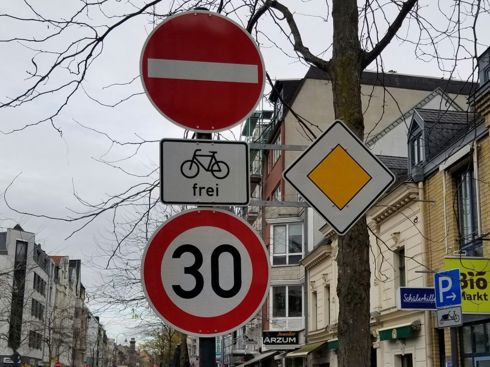Ein Einbahnstraßenschild und ein Tempo-30-Schild sind auf dem Foto zu sehen.