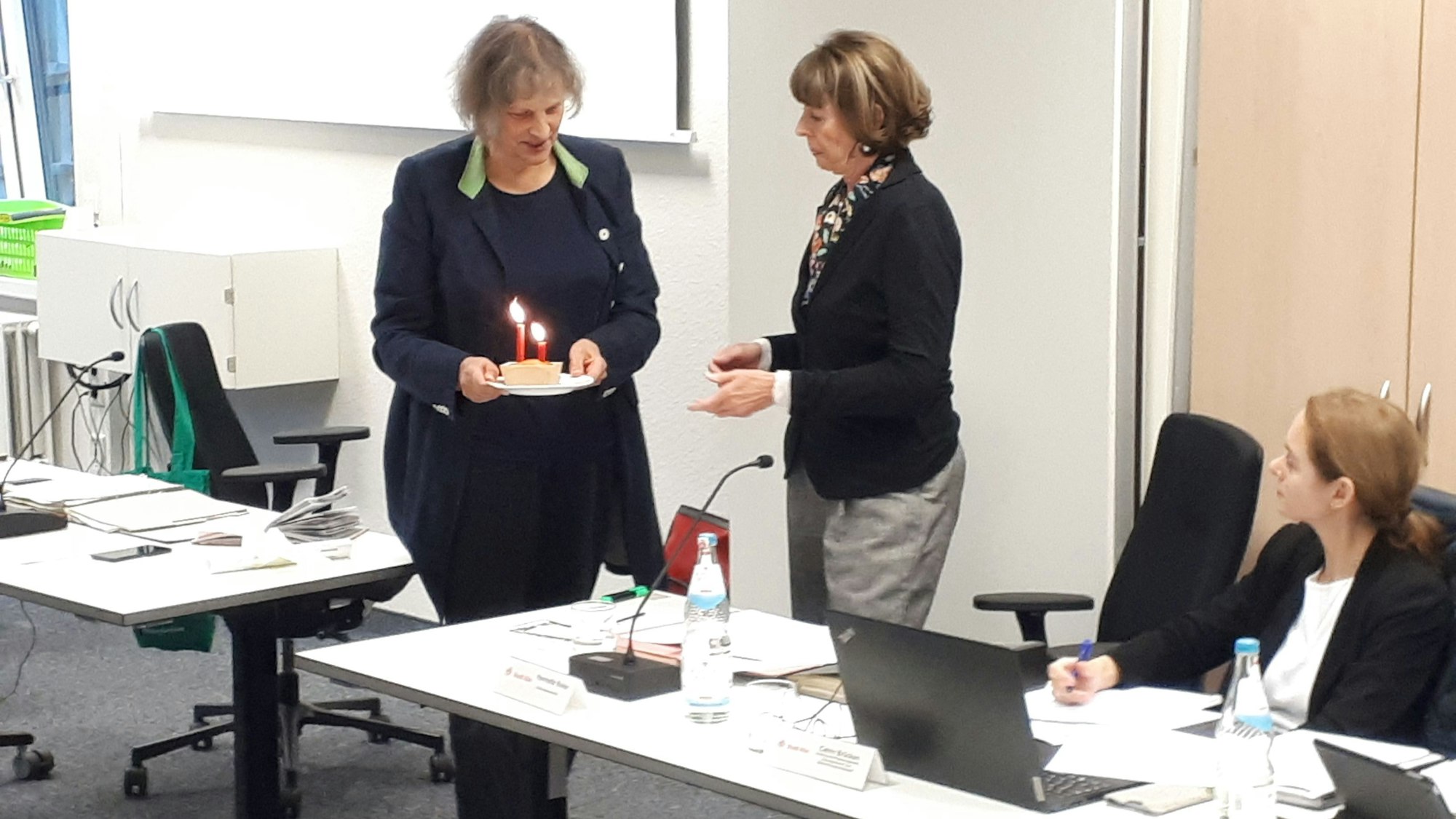 Bezirksbrgermeisterin Diana Siebert (l.) überreicht Henriette Reker die "Geburtstagstorte".