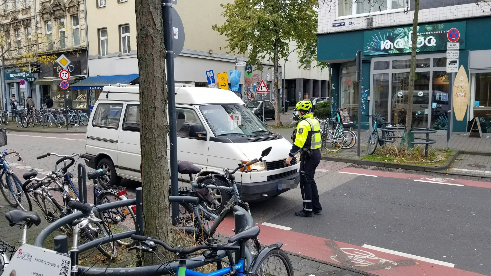 Ein Polizist hält ein Auto auf der Venloer Straße an.