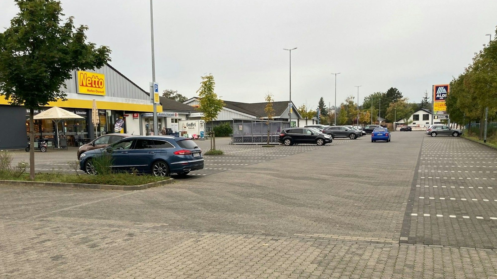 Das Bild zeigt einen Parkplatz von mehreren Discountern.