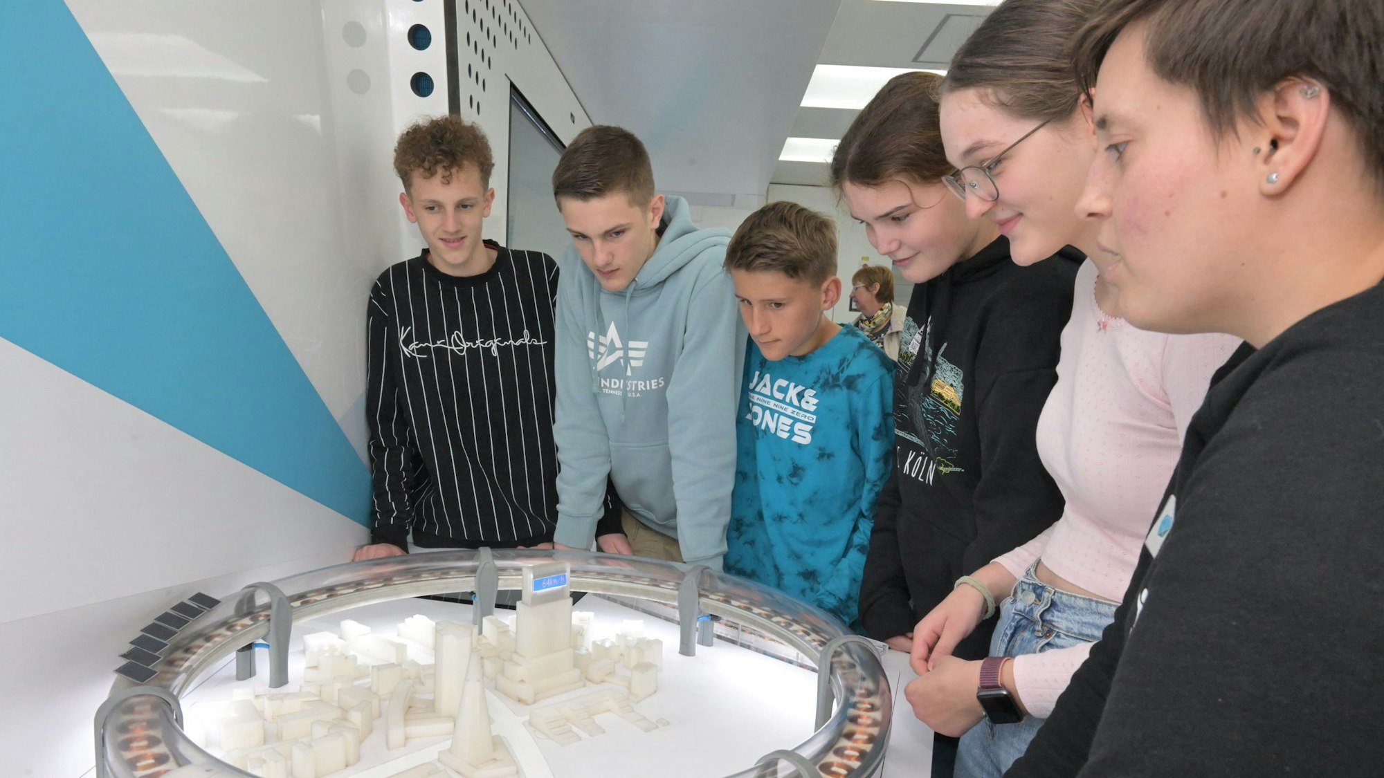 Die Schüler betrachten ein Modell des Hyperloop.
