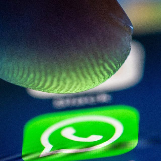 Ein Finger nähert sich dem Whatsapp-Logo auf einem Smartphone.