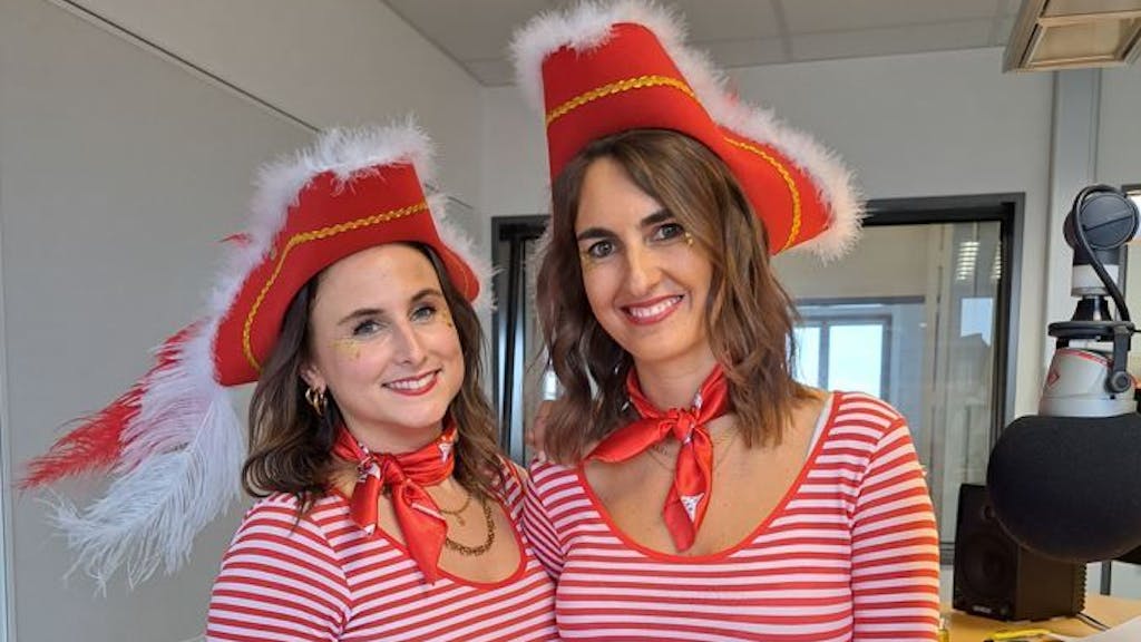 Zwei Frauen in rot-weißen Ringelshirts stehen in einem Studio und lächeln in die Kamera.