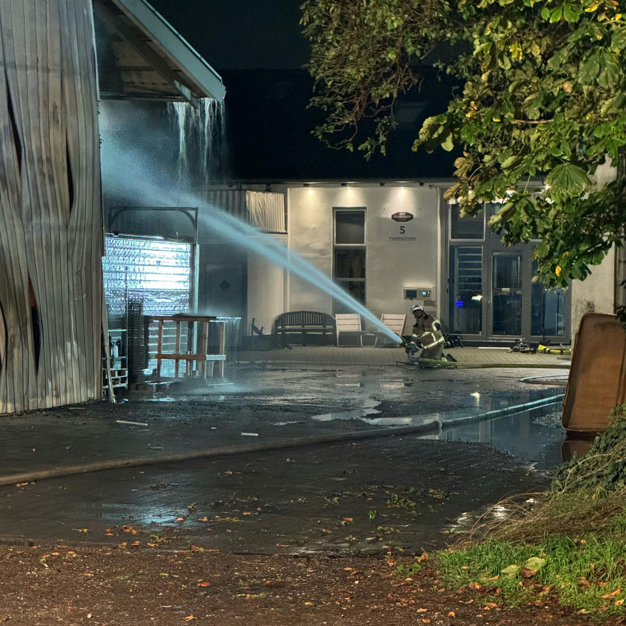 Ein Feuerwehrmann löscht das Feuer in der Lagerhalle.