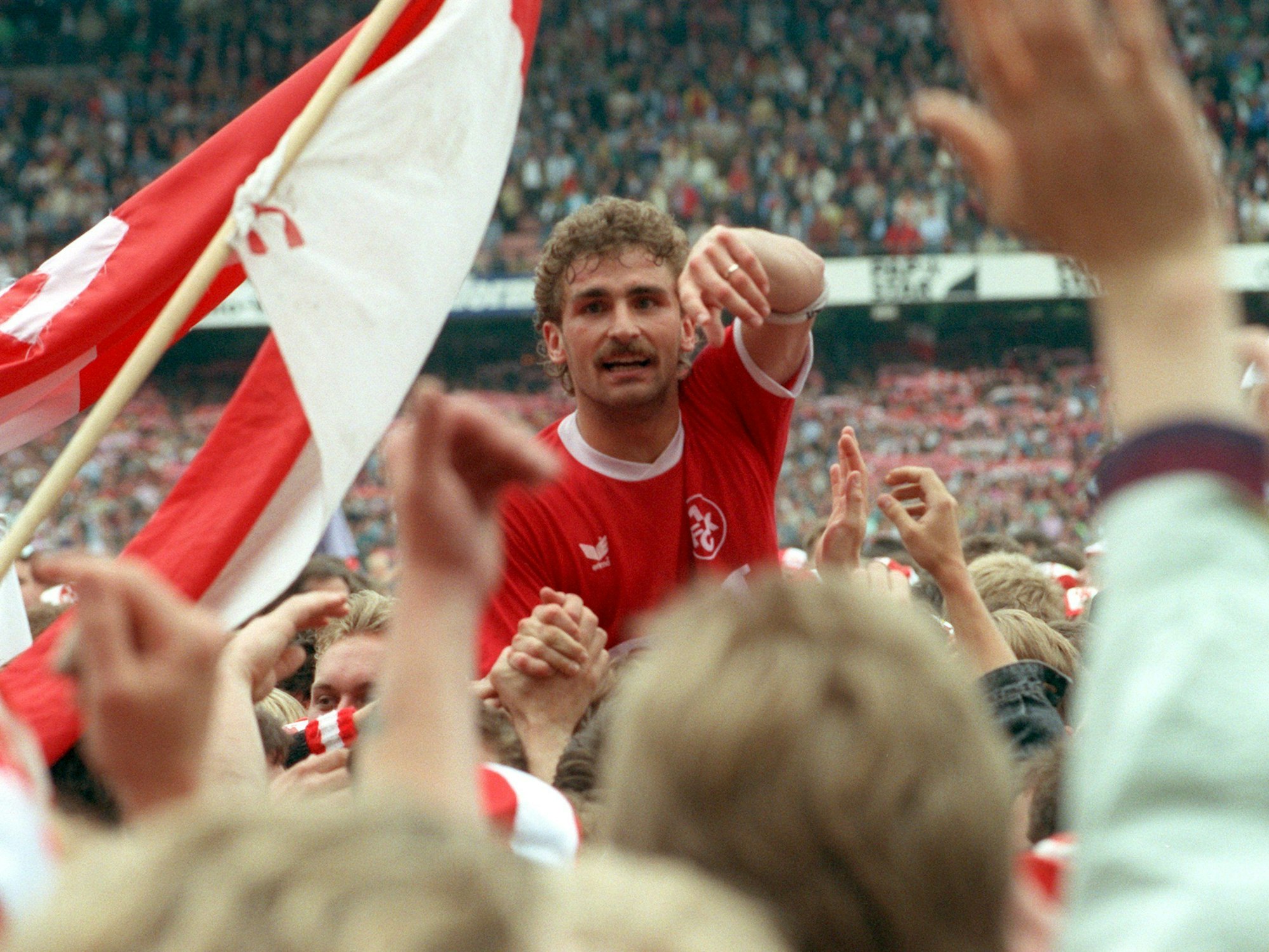 Stefan Kuntz wird auf Schultern getragen und inmitten von Fahnen und jubelnden Händen im Stadion gefeiert.