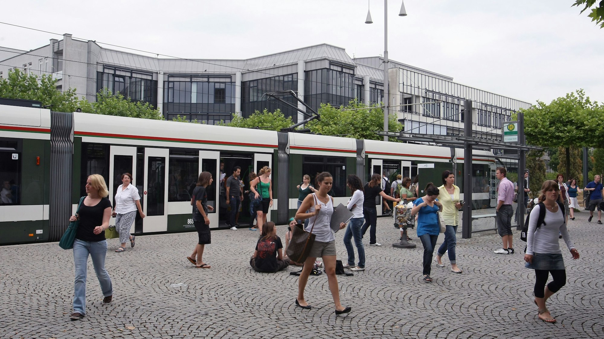 Studierende verlassen an der Haltestelle Universität in Augsburg (Schwaben) die Straßenbahn.