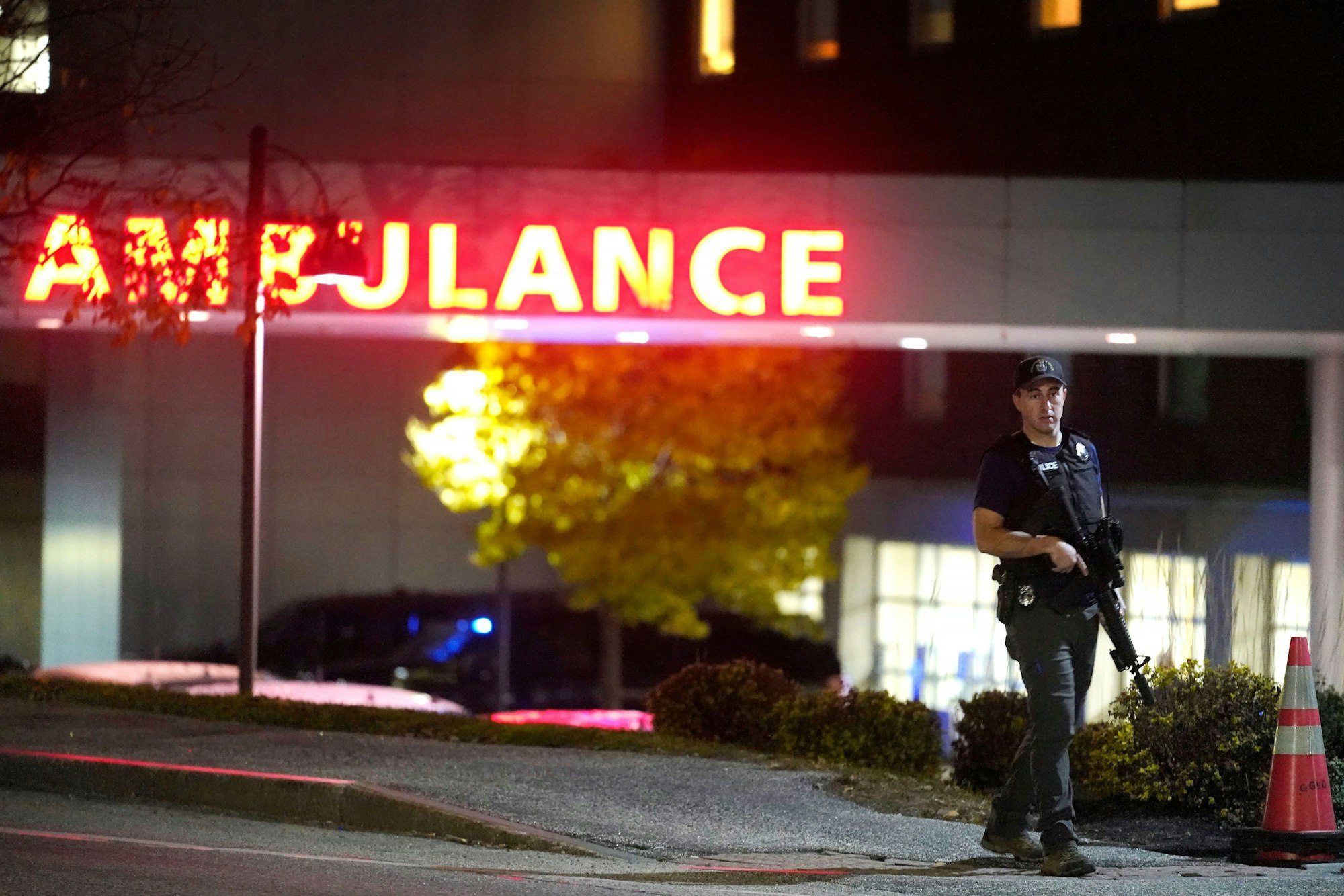 Ein Polizist steht nahe einem Gebäude in Lewiston (USA), ein Schütze hatte zuvor das Feuer eröffnet und viele Menschen getötet.