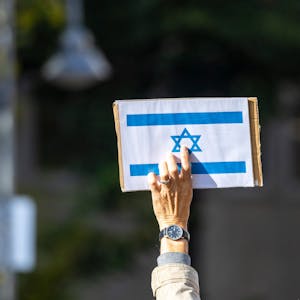 Ein Teilnehmer der Kundgebung «Aufstehen gegen Israelhass und Antisemitismus» hält ein Schild mit der israelischen Flagge in die Höhe.&nbsp;