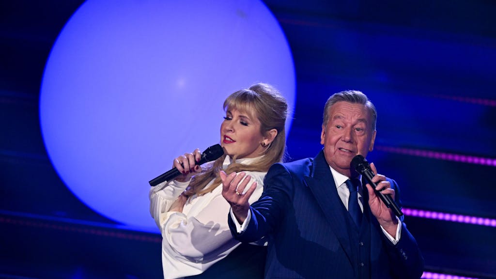 Sängerin Maite Kelly und der deutsche Schlagersänger Roland Kaiser stehen während der Fernsehshow „Der große Schlagerabschied“ gemeinsam auf der Bühne.