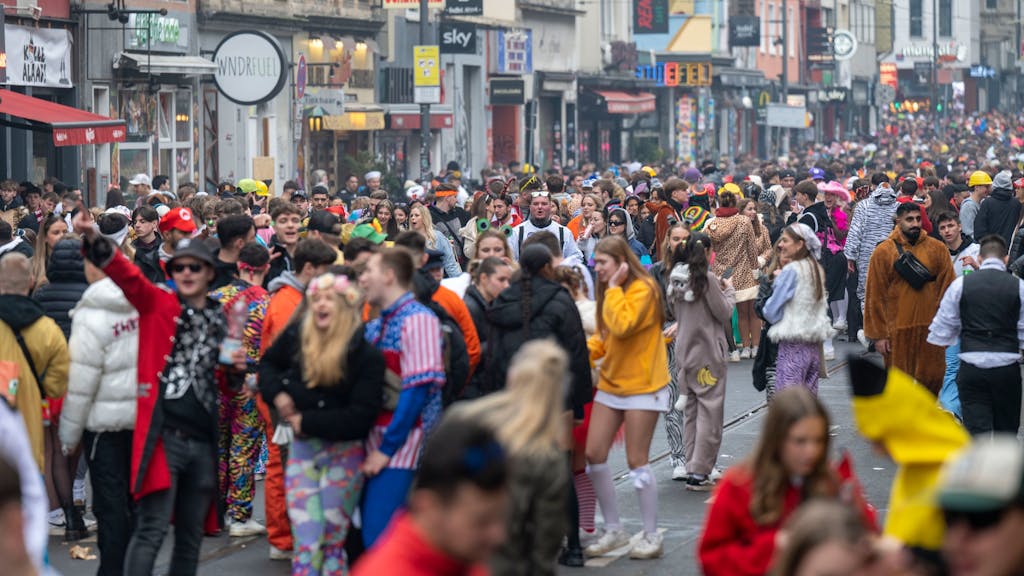 Tausende feiernde Menschen in Kostümen stehen auf der Zülpicher Straße in Köln.