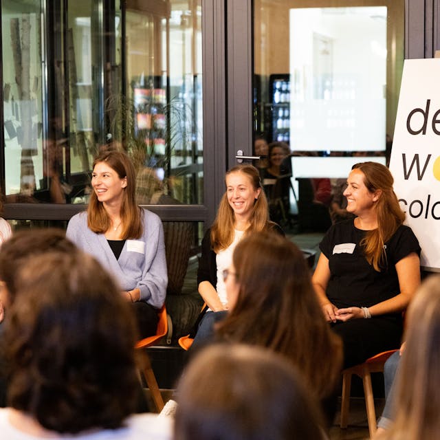 Fünf junge Frauen sitzen auf Stühlen nebeneinander und diskutieren vor Publikum.