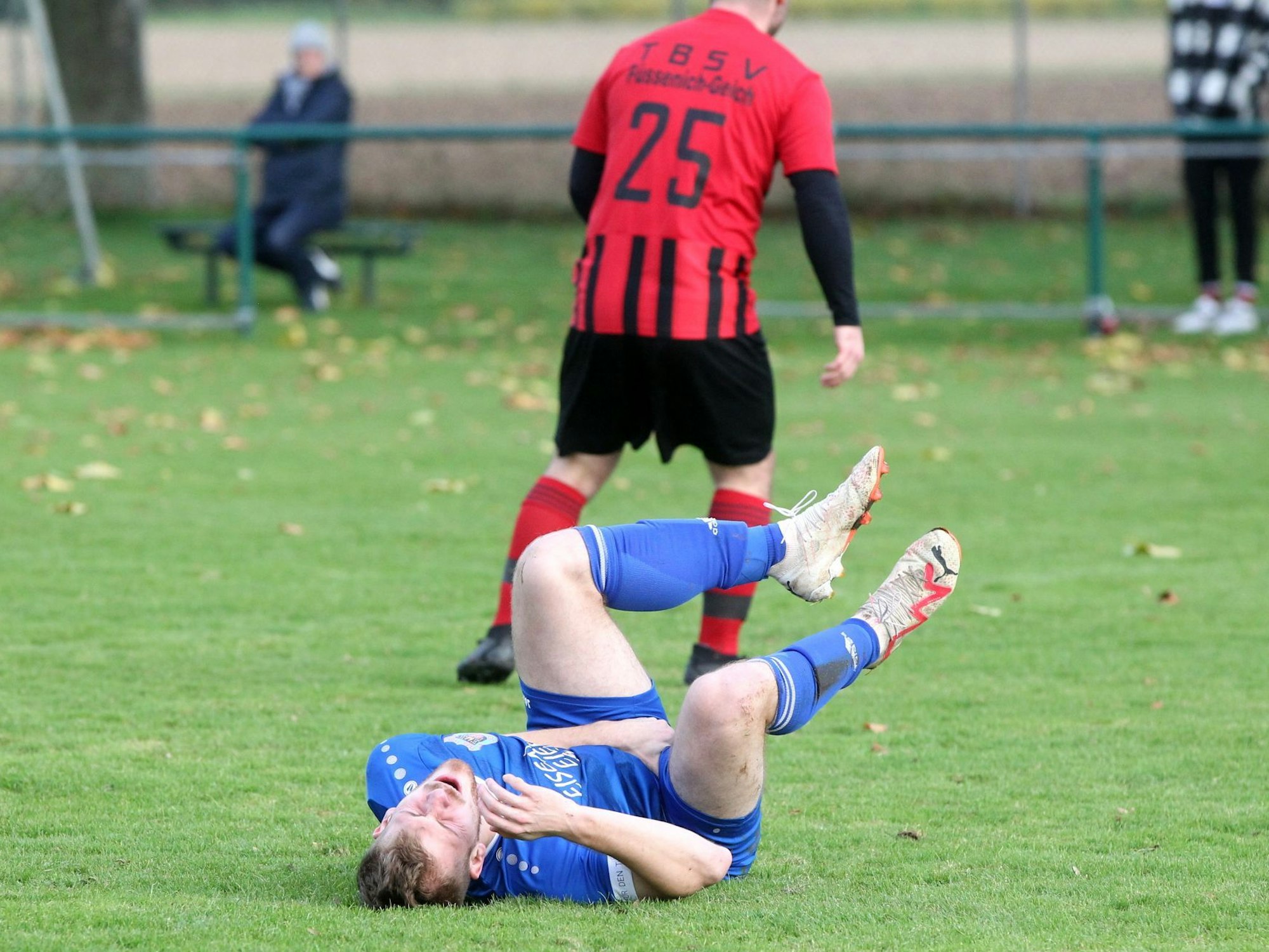 Ein Spieler von Dom-Esch wälzt sich auf dem Boden, nachdem der Ball ihn dahin getroffen hat, wo es weh tut.