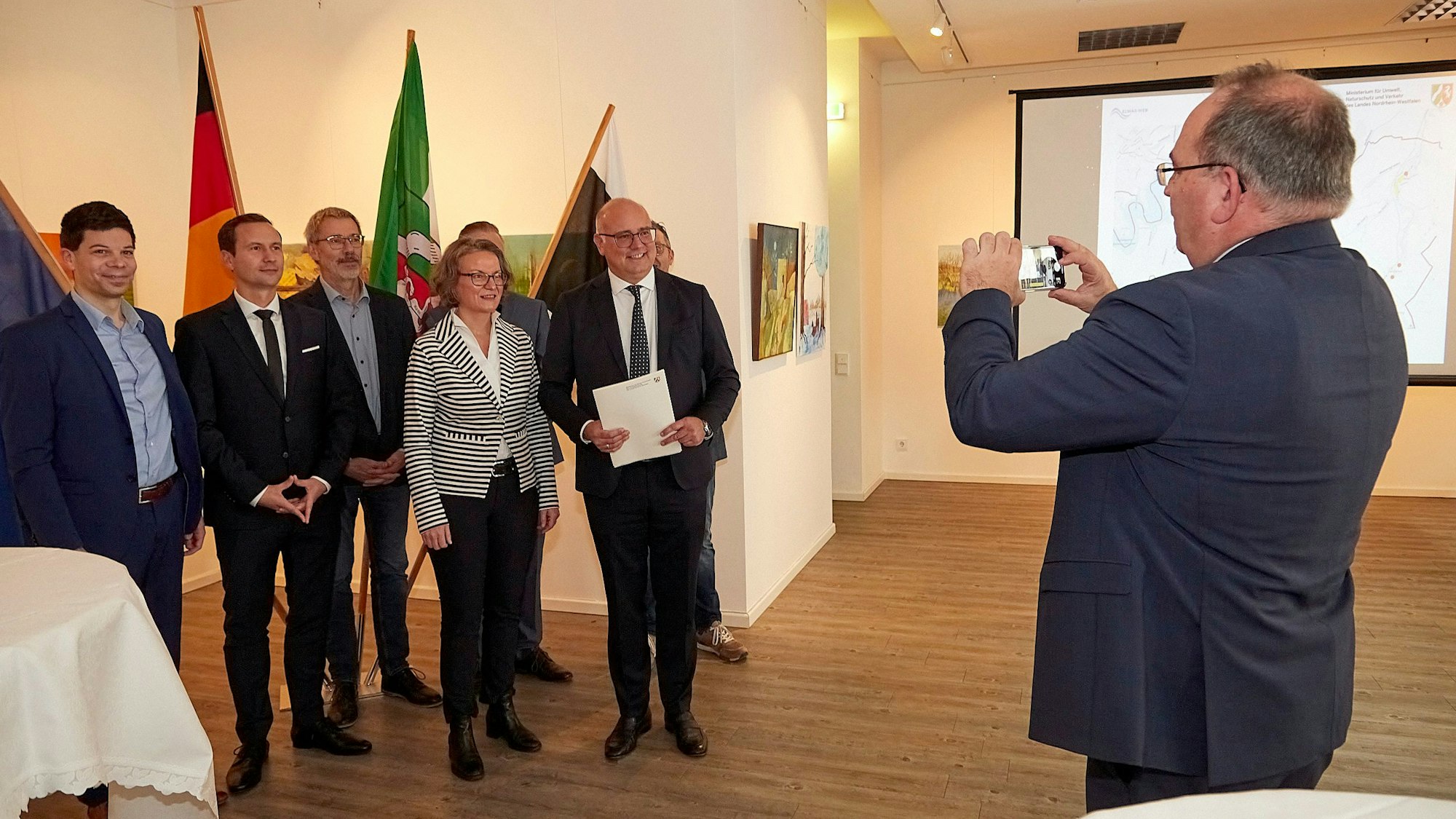CDU-Landtagsmitglied Dr. Ralf Nolten macht ein Foto von Ministerin Ina Scharrenbach, Bürgermeister Jochen Weiler und Mitarbeitern der Verwaltung. Weiler hält den Bewilligungsbescheid in den Händen.