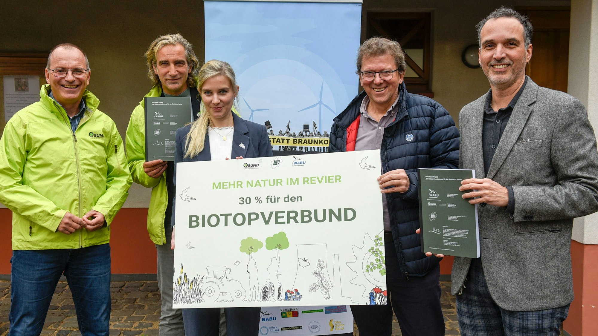 Auf dem Foto sind Vertreter der Naturschutzverbände BUND und NABU zu sehen. Auf einem Schild, das sie festhalten, ist zu lesen „Mehr Natur im Revier. 30 Prozent für den Biotopverbund“.