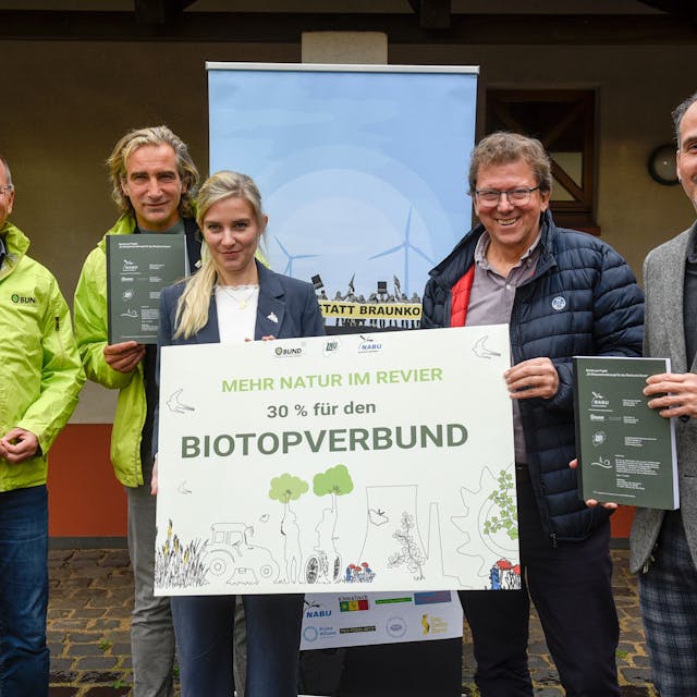 Auf dem Foto sind Vertreter der Naturschutzverbände BUND und NABU zu sehen. Auf einem Schild, das sie festhalten, ist zu lesen „Mehr Natur im Revier. 30 Prozent für den Biotopverbund“.