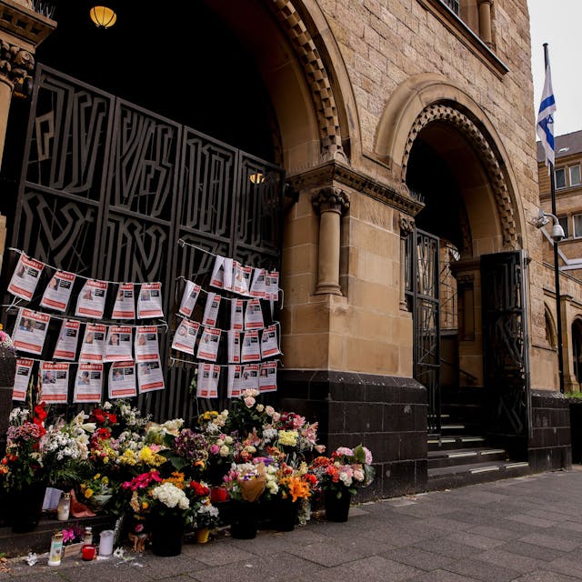 Blumen und Steckbriefe von seit dem Angriff der Hamas Vermissten Israelis hängen an der Synagoge an der Roonstraße in Köln.