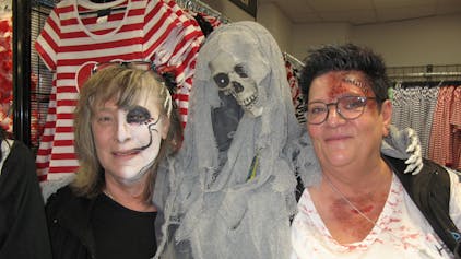 Das Bild zeigt zwei Frauen im Kostümgeschäft Deiters mit einem Skelett und zum Gruseln geschminkten Gesichtern.