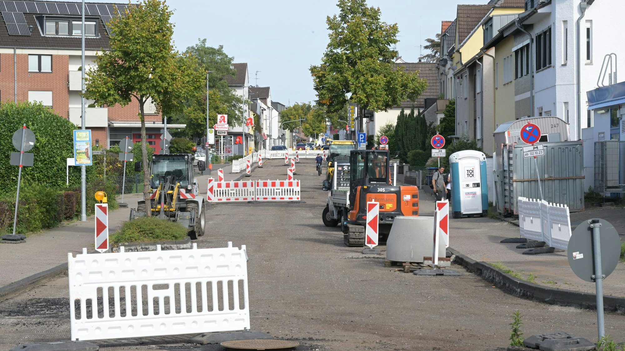 Warnbaken und Baufahrzeuge stehen auf der Handstraße in Bergisch Gladbach-Hand.