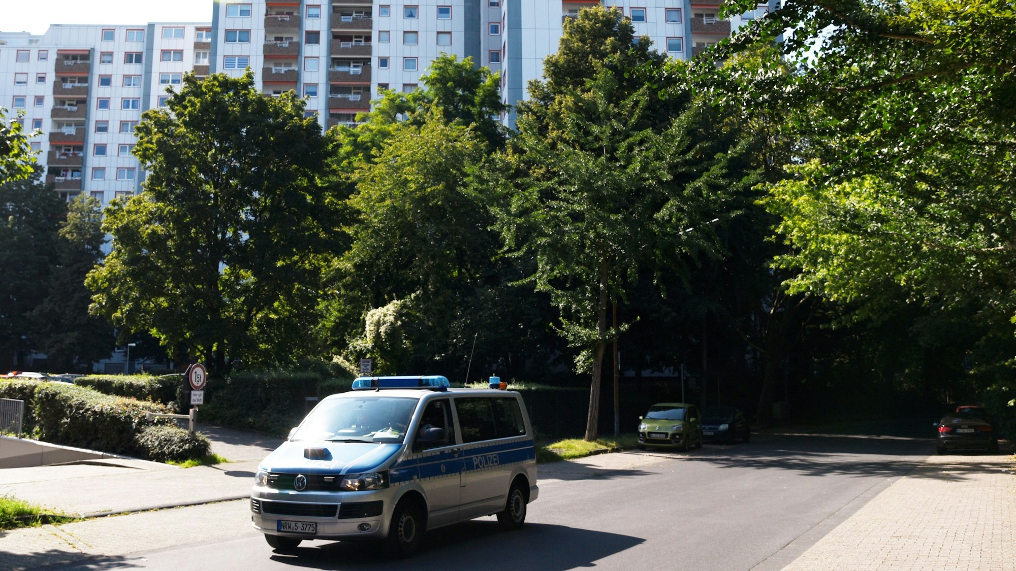 Polizei-Auto fährt durch ein Wohngebiet in Köln.