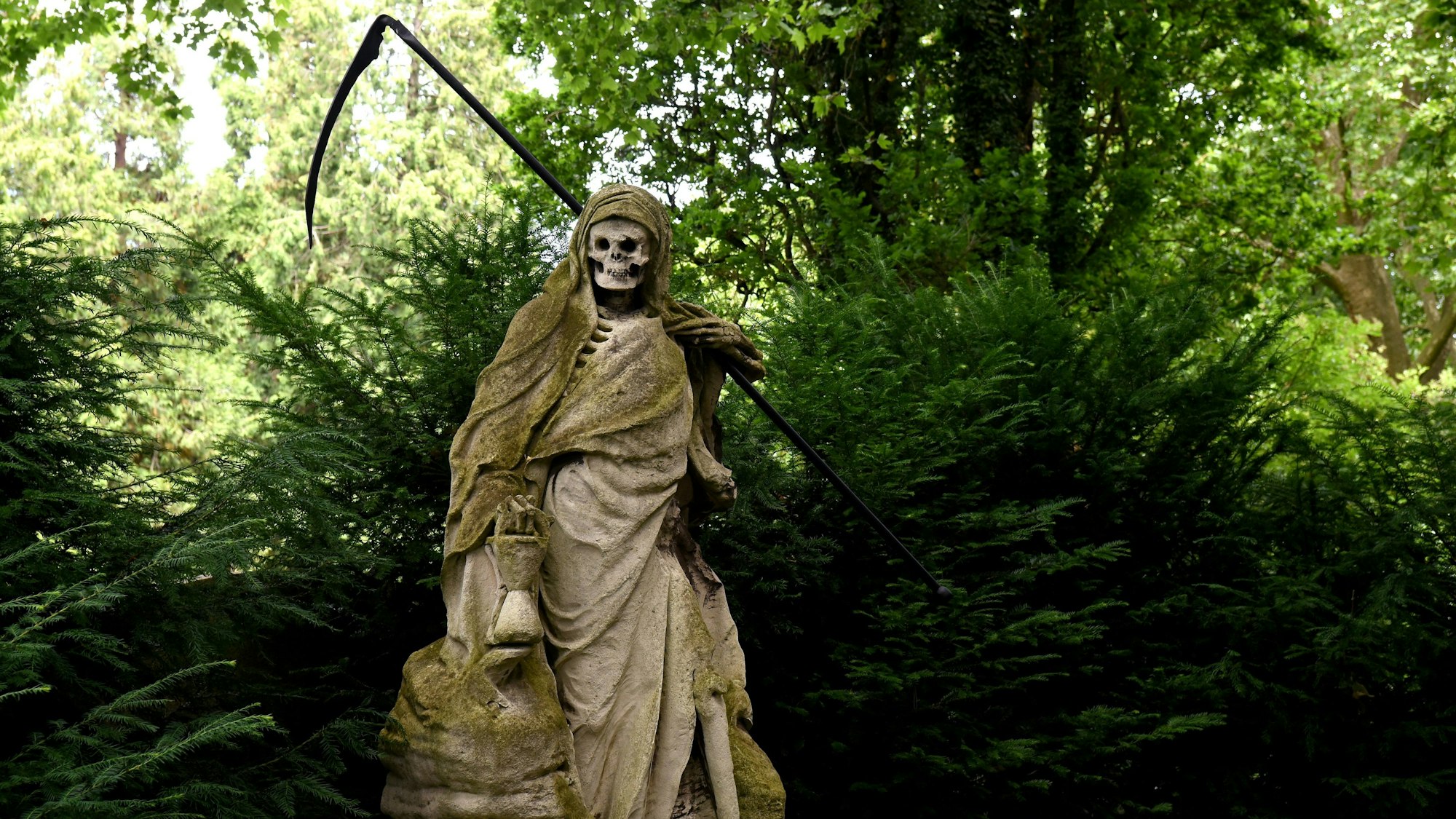 Skulptur mit Sense auf einem Friedhof