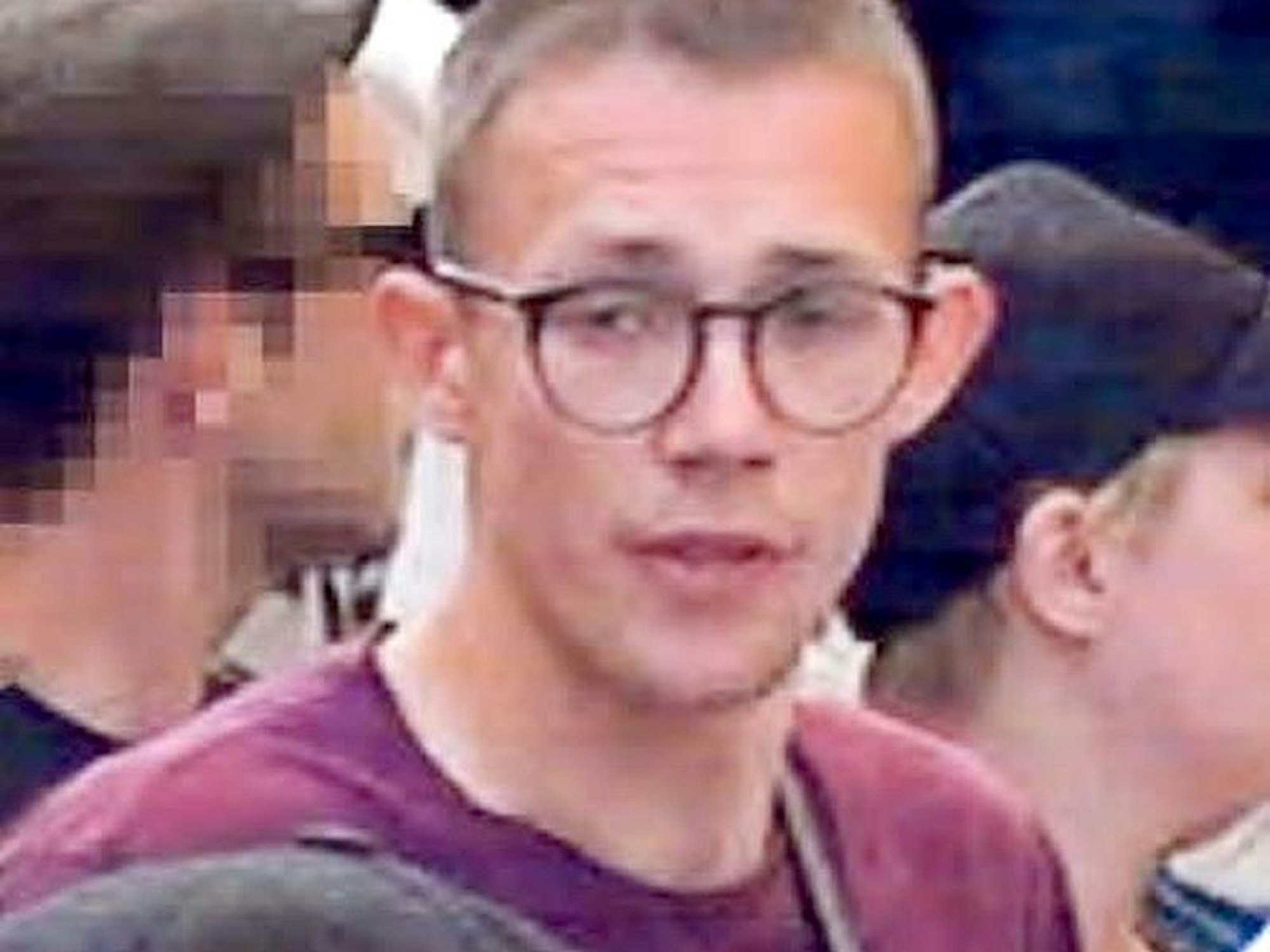 Junger Mann mit Brille und rotem Shirt auf einem Fahndungsfoto.