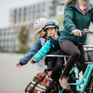 Frau fährt mit zwei Kindern auf dem Fahrrad Foto: Getty Images/RyanJLane