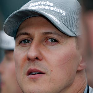 Michael Schumacher blickt kurz vor dem Start eines Formel-1-Rennens in die Kamera. Er trägt eine Kappe seines Teams Mercedes. Mit Ferrari wurde Schumacher zwischen 2000 und 2004 fünfmal Formel-1-Weltmeister.