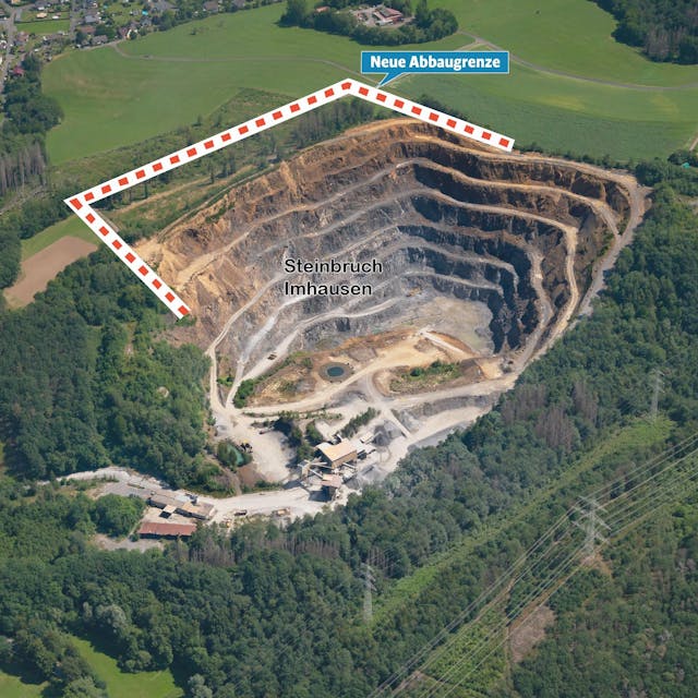 Das Bild zeigt eine Luftaufnahme des Steinbruchs mit der nahe gelegenen Ortschaft Imhausen.