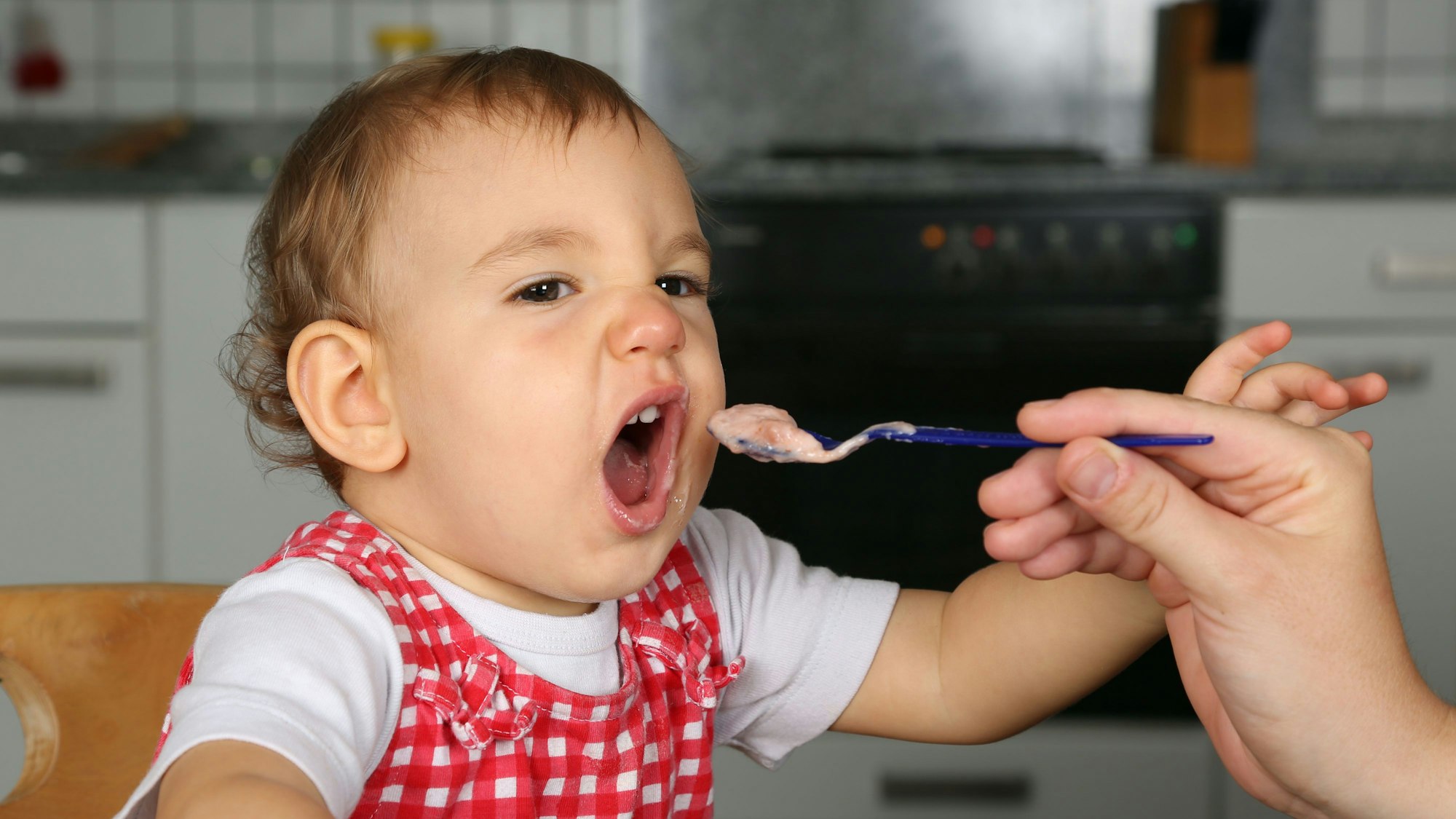 Ein Kleinkind wird mit Brei gefüttert (Symbolbild)