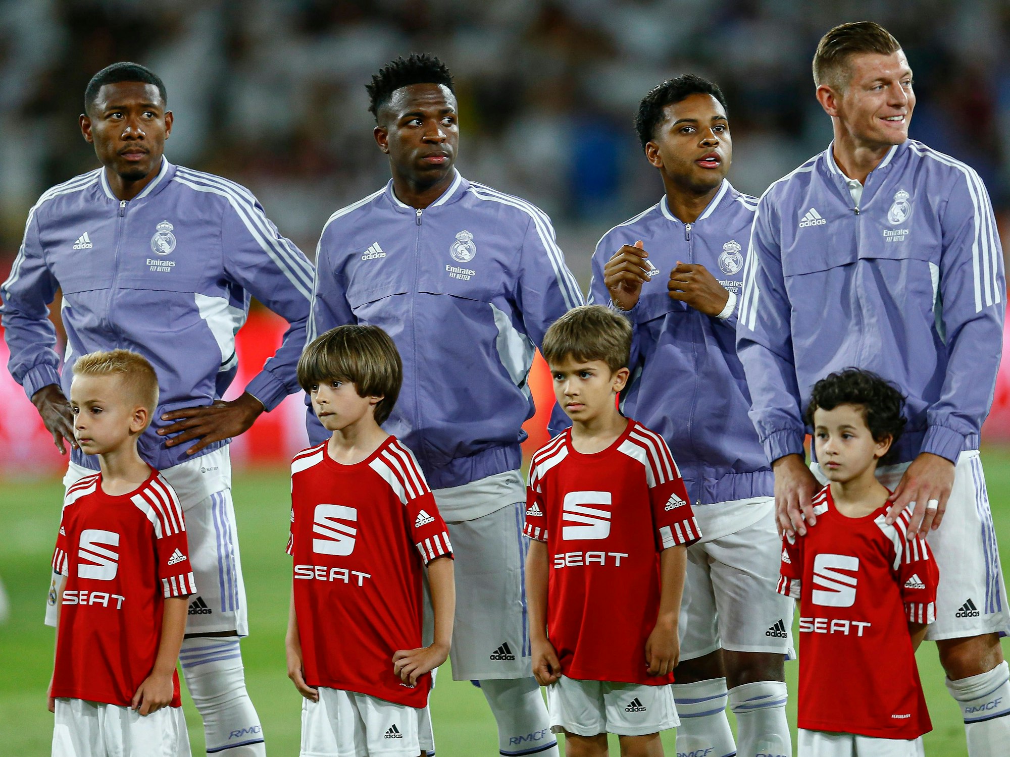 Die Real-Madrid-Spieler David Alaba, Vinicius, Rodrygo und Toni Kroos stehen hinter den Einlaufkindern.