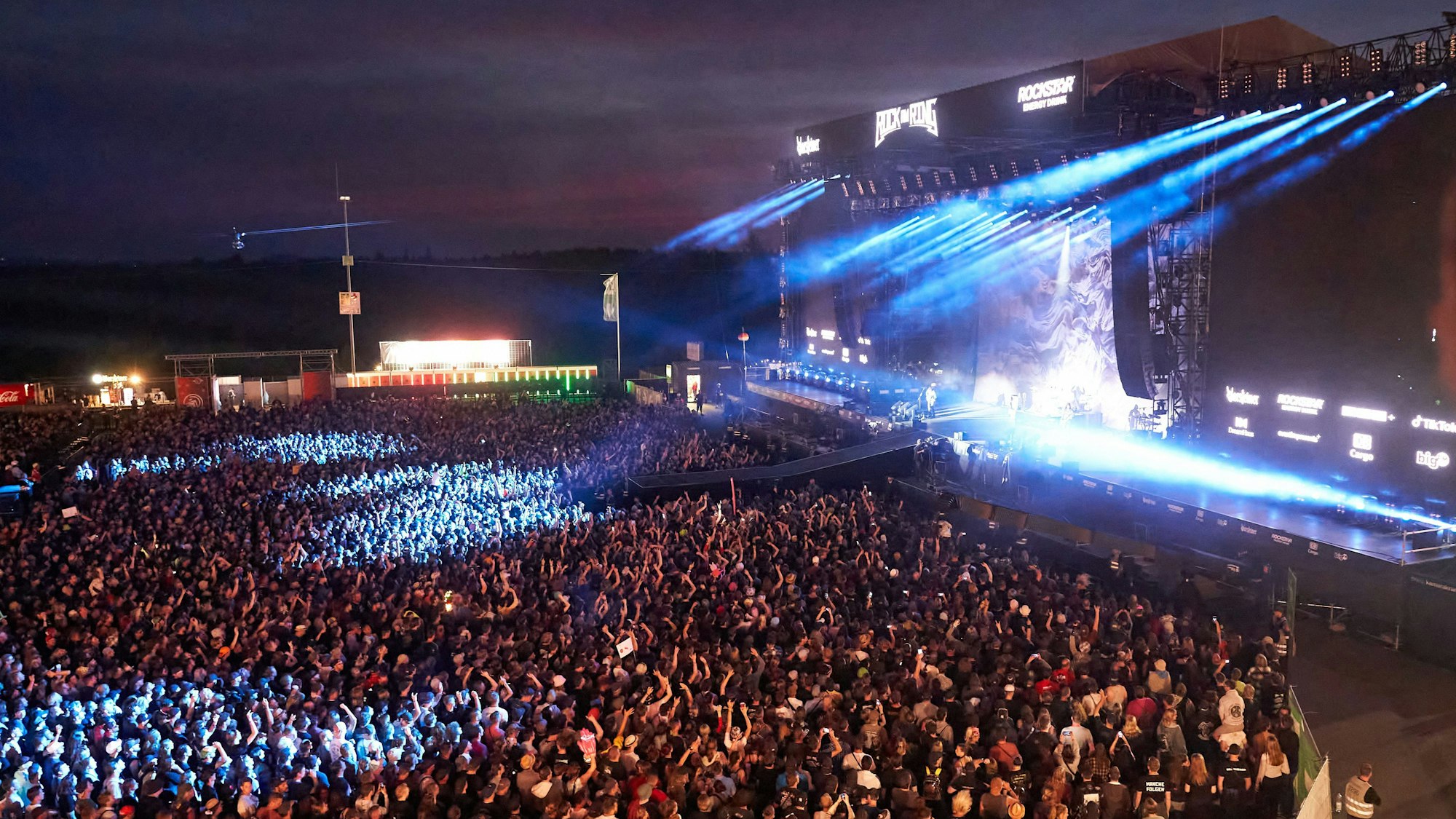 Rheinland-Pfalz, Nürburg: Fans stehen beim Auftritt der britischen Rockband „Muse“ vor der Hauptbühne des Festivals Rock am Ring. (Archivbild)