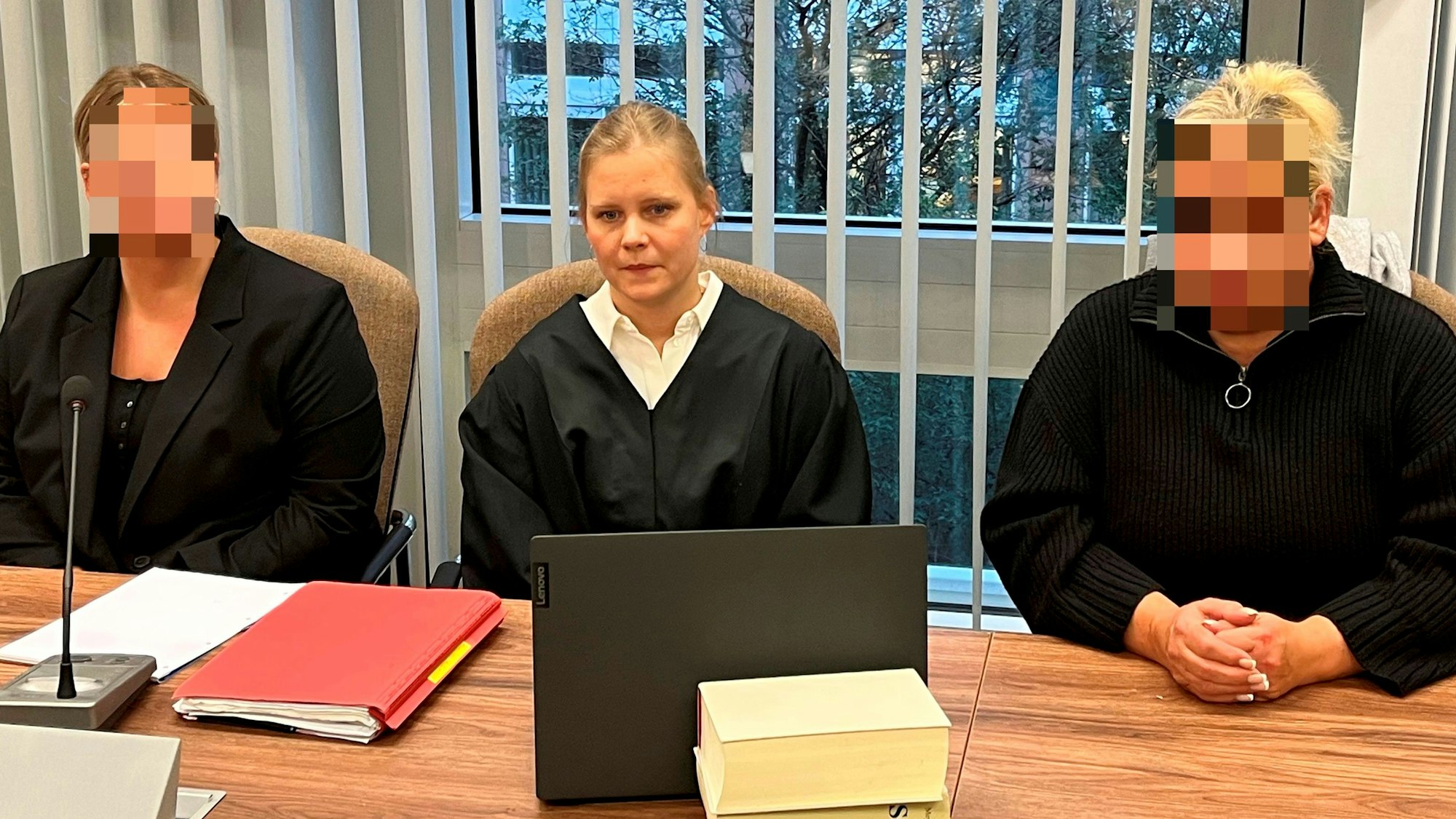 Drei Frauen sitzen im Gerichtssaal am Tisch der Nebenklage.