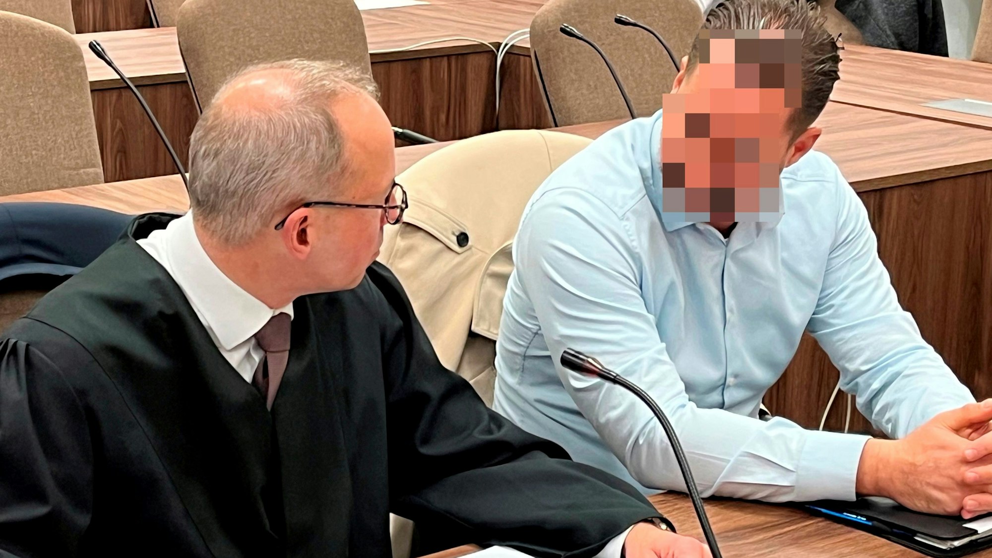 Zwei Männer unterhalten sich im Gericht.