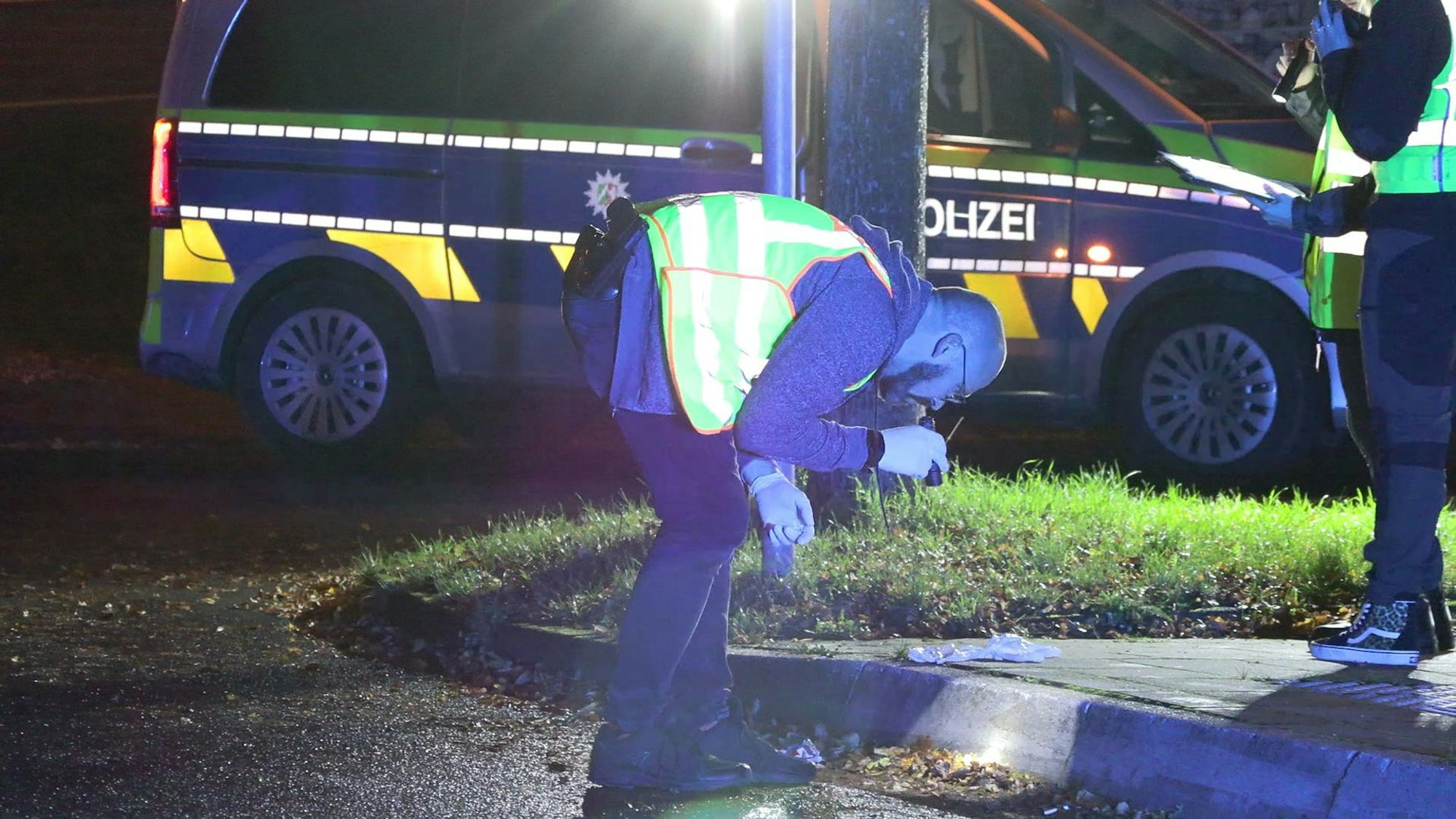 Ermittler untersuchen die Spuren nach den Polizeischüssen auf einen 16-Jährigen in der Döbrabergstraße in Köln-Blumenberg.