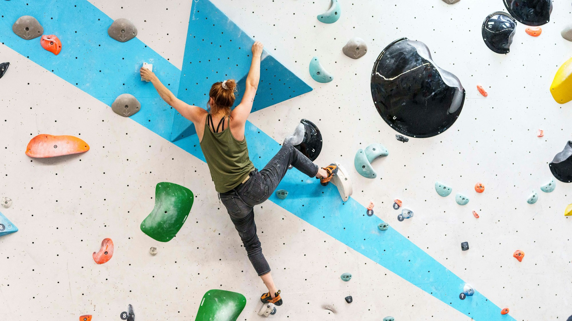 Eine Frau bouldert an einer Wand der Kletterhalle «Boulderwelt Frankfurt».