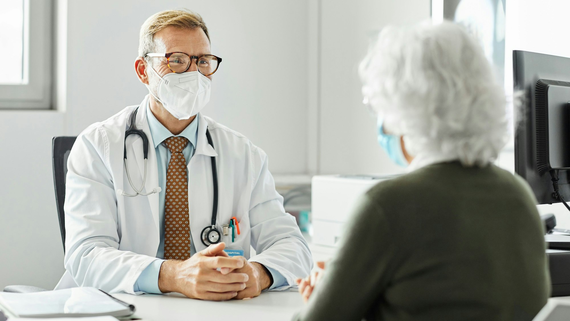 Ein Arzt spricht mit einer Patientin (gestelltes Foto).