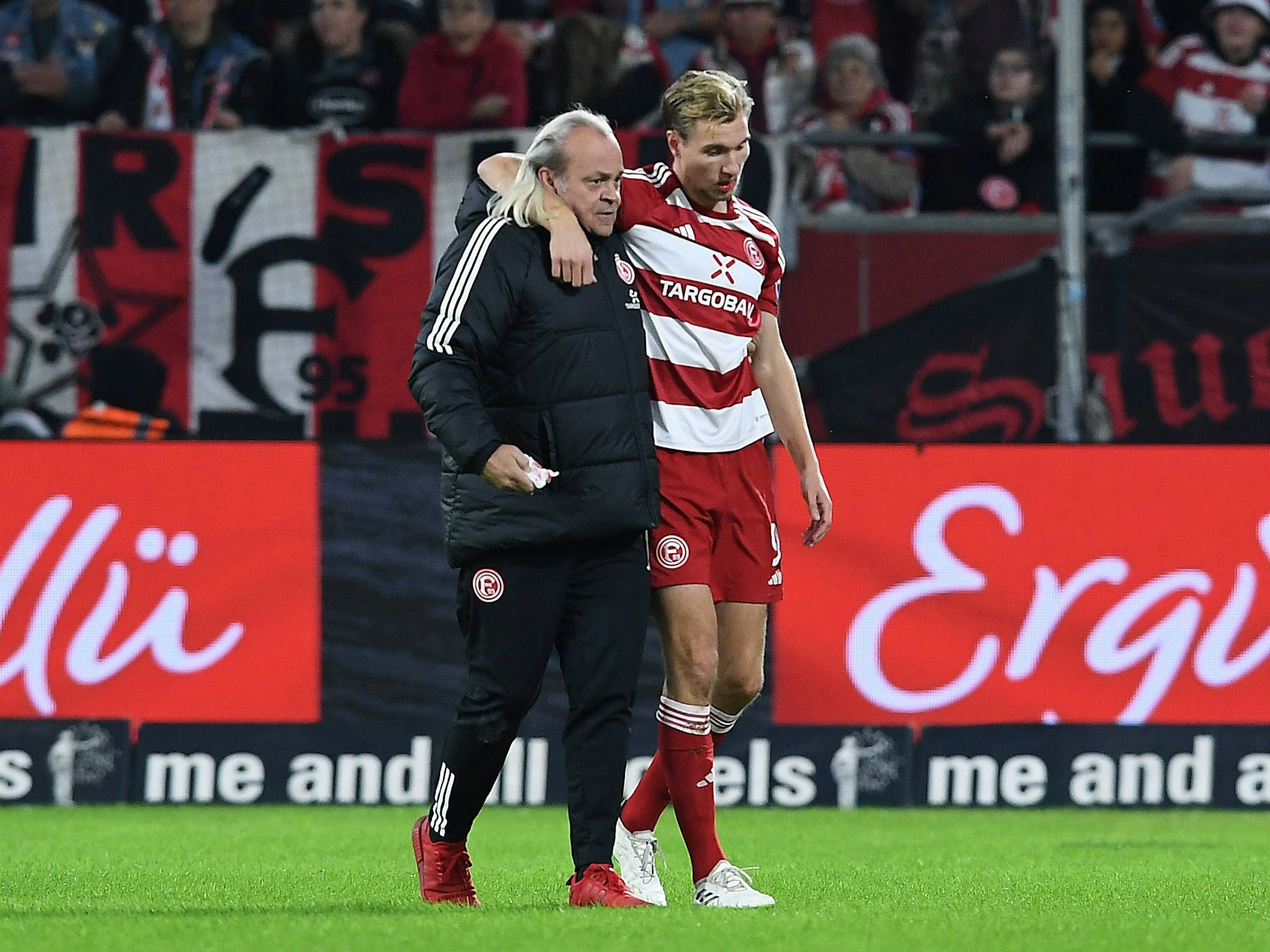 Fortuna Düsseldorfs Stürmer Vincent Vermeij verlässt gestützt von Team-Arzt Ulf Blecker beim Spiel gegen Wehen Wiesbaden den Platz.