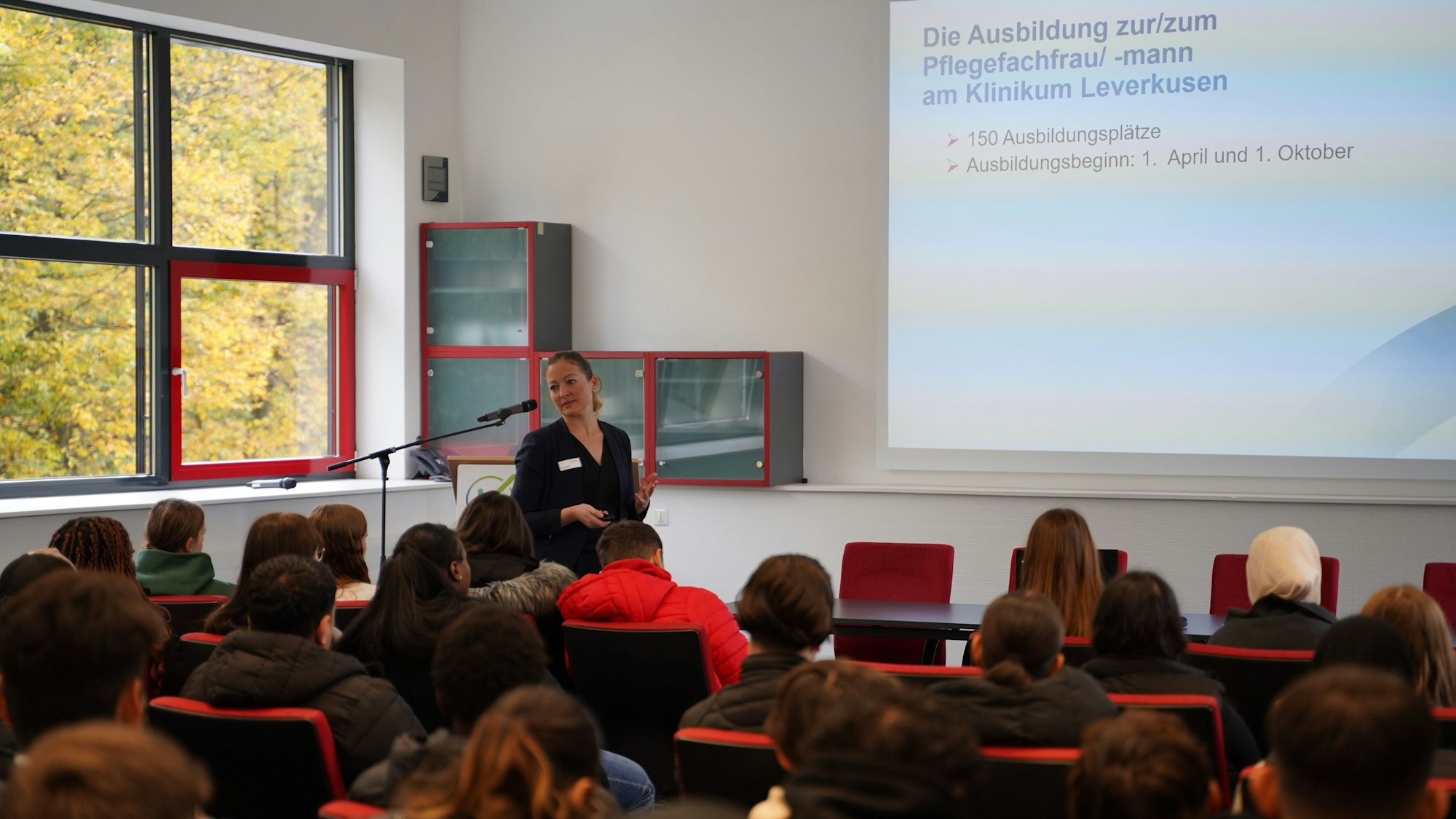 Monika Gruna, Praxiskoordinatorin im Klinikum Leverkusen, erklärt den Schülerinnen und Schülern des Geschwister-Scholl-Berufskollegs Einzelheiten des Pflegeberufs.