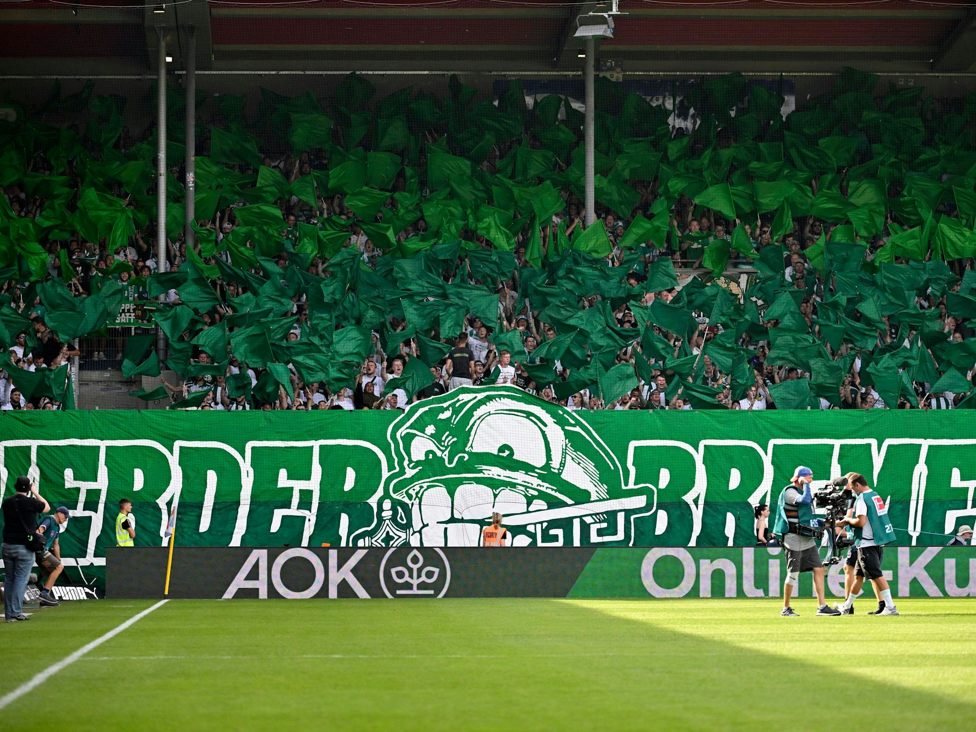 Choreographie von Werder-Fans mit grünen Fahnen und Spruchband.