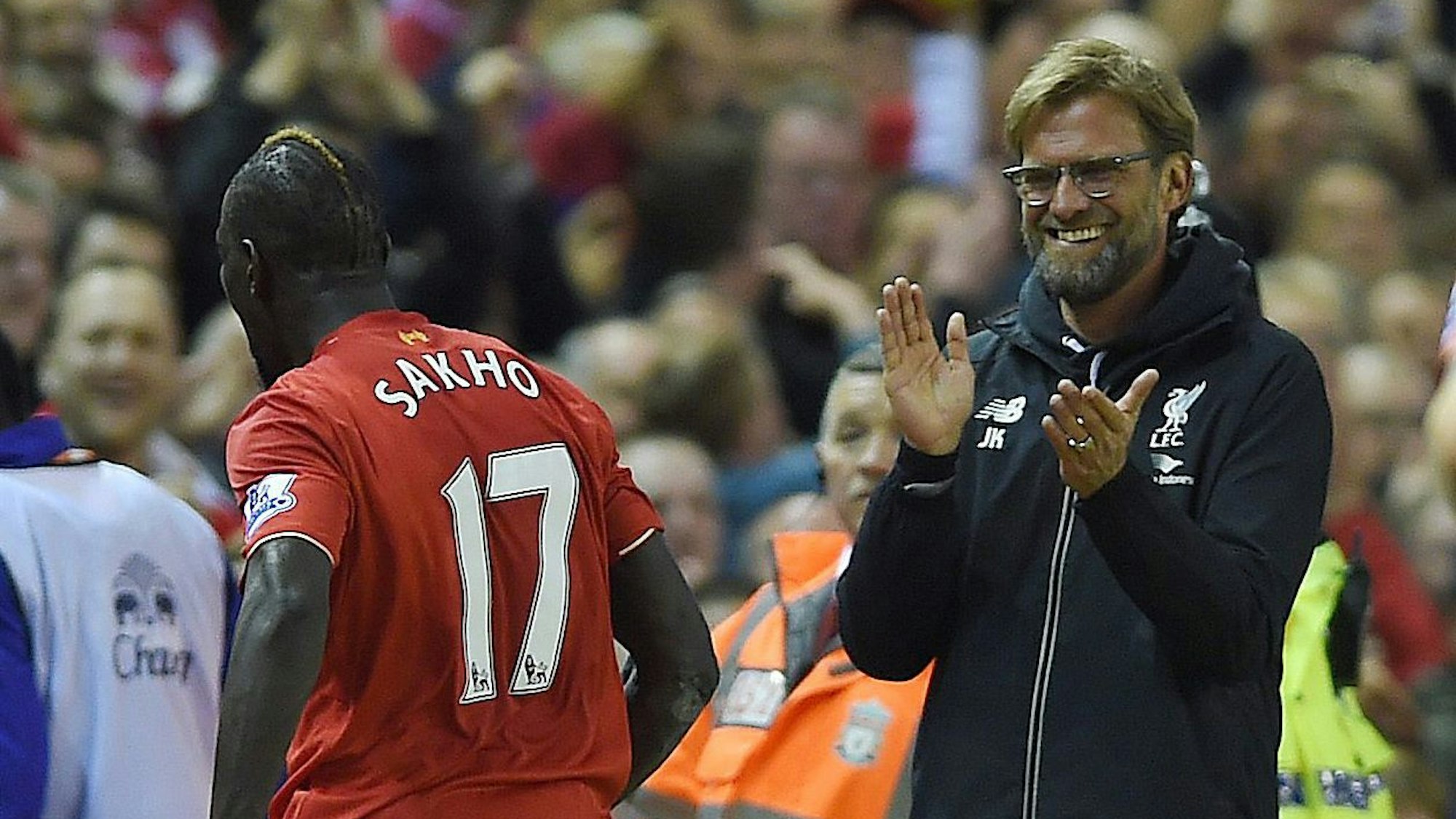 Liverpool-Trainer Jürgen Klopp applaudiert grinsend seinem Spieler Mamadou Sakho.
